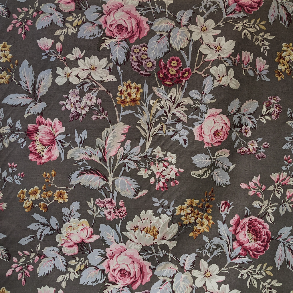 Floral patterned fabric with pink, white, and yellow flowers on a dark background
