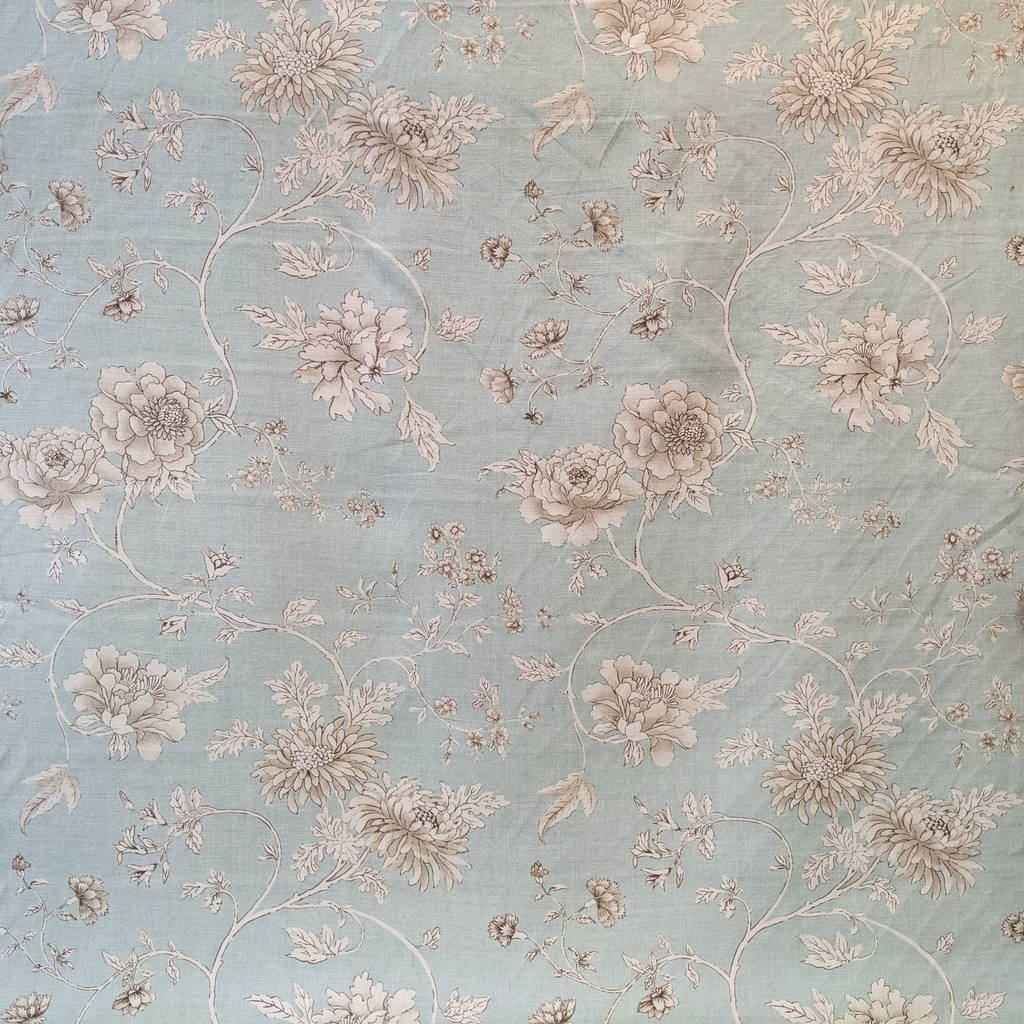 Floral patterned fabric with beige flowers on a light blue background
