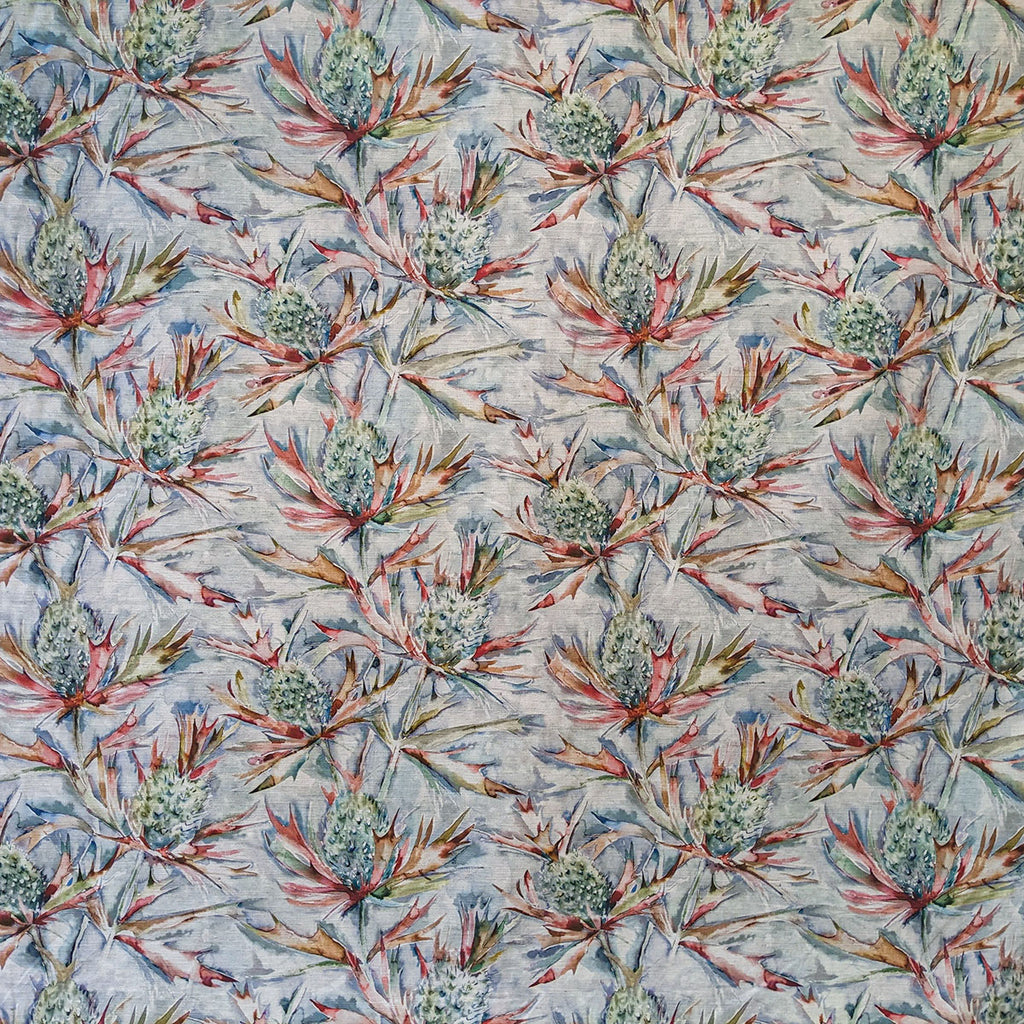 Thistle-patterned fabric with red and green leaves on a light blue background