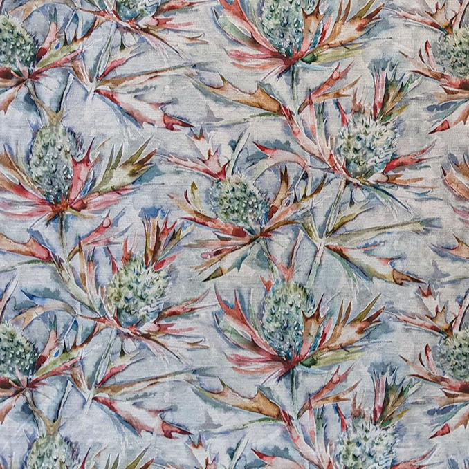 Thistle-patterned fabric with red and green leaves on a light blue background