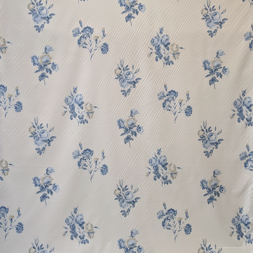 Fabric with blue floral pattern on a textured beige background