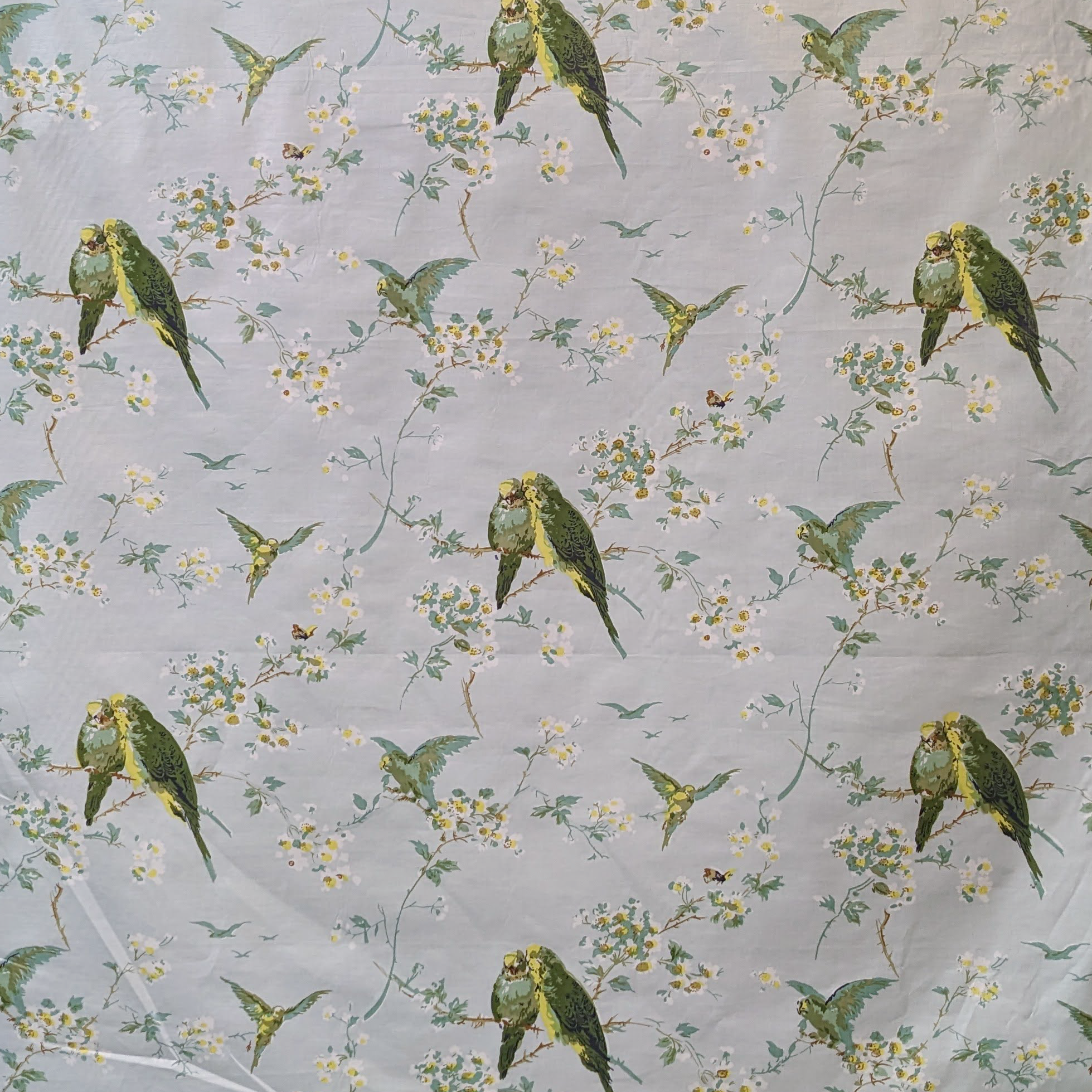 Pattern of green parrots and yellow flowers on a gray background