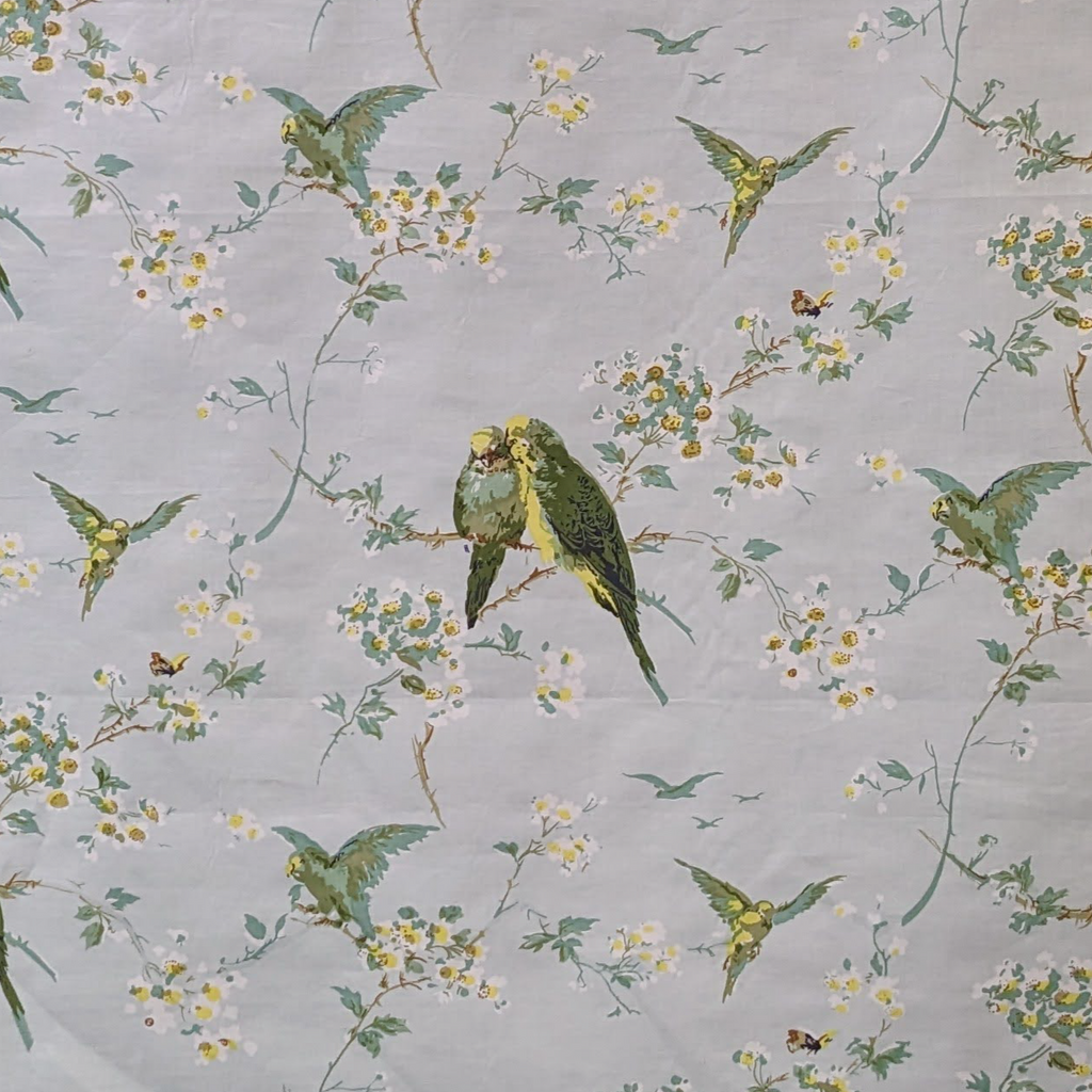 Patterned fabric with parrots and flowers on a gray background