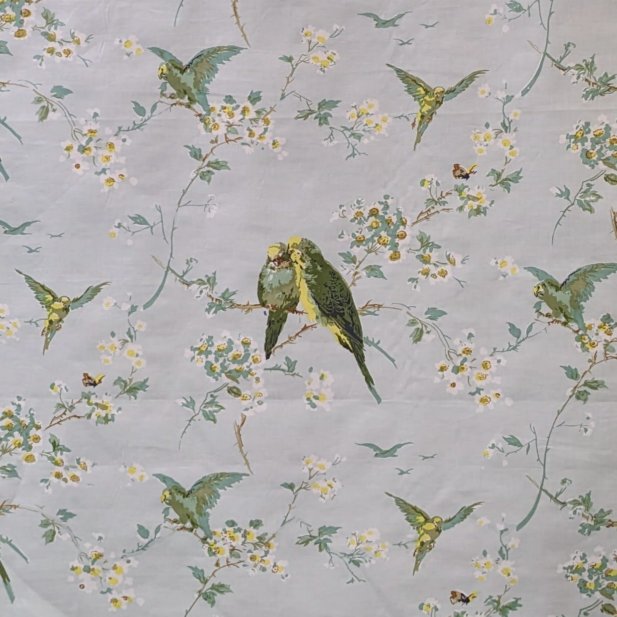 Pattern of green parrots and yellow flowers on a gray background