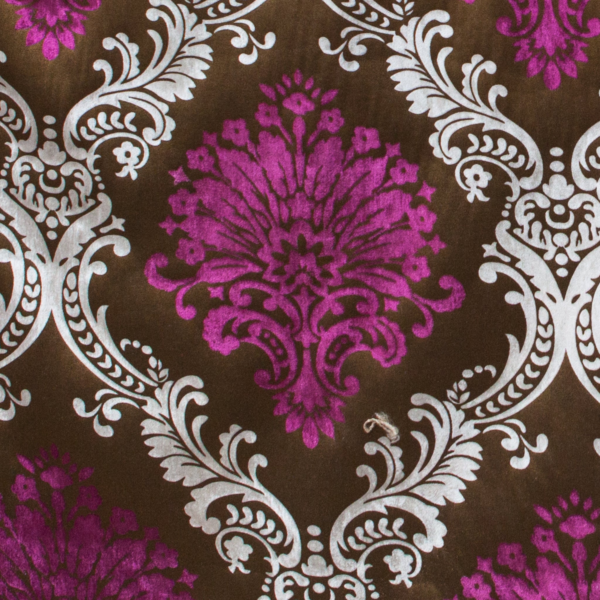 Decorative fabric with purple and white floral pattern on a brown background