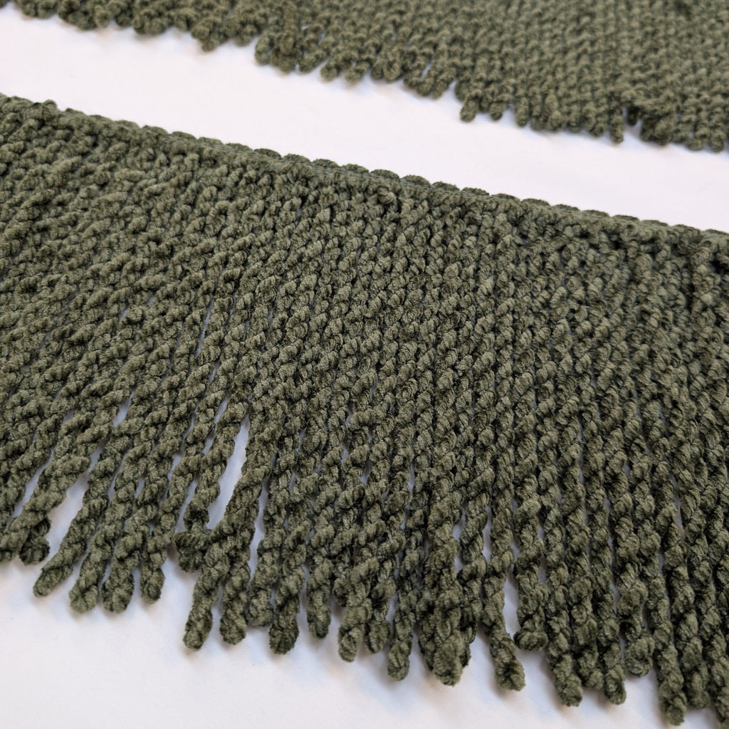 Close-up of green fringe fabric on a white background
