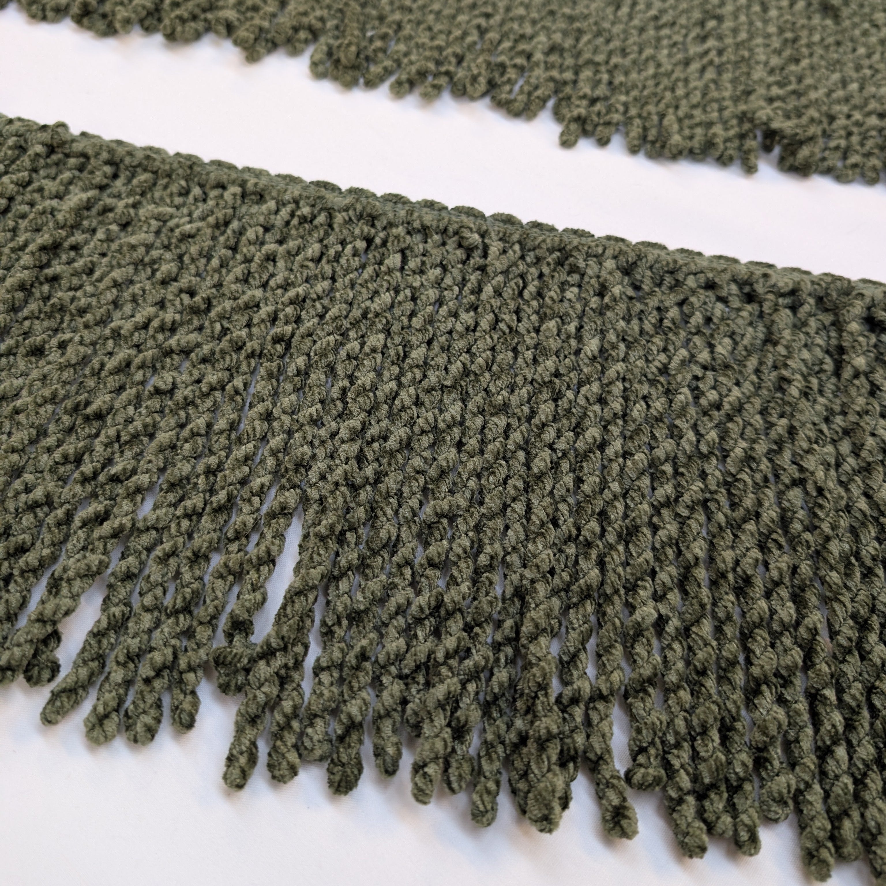 Close-up of green fringe fabric on a white background