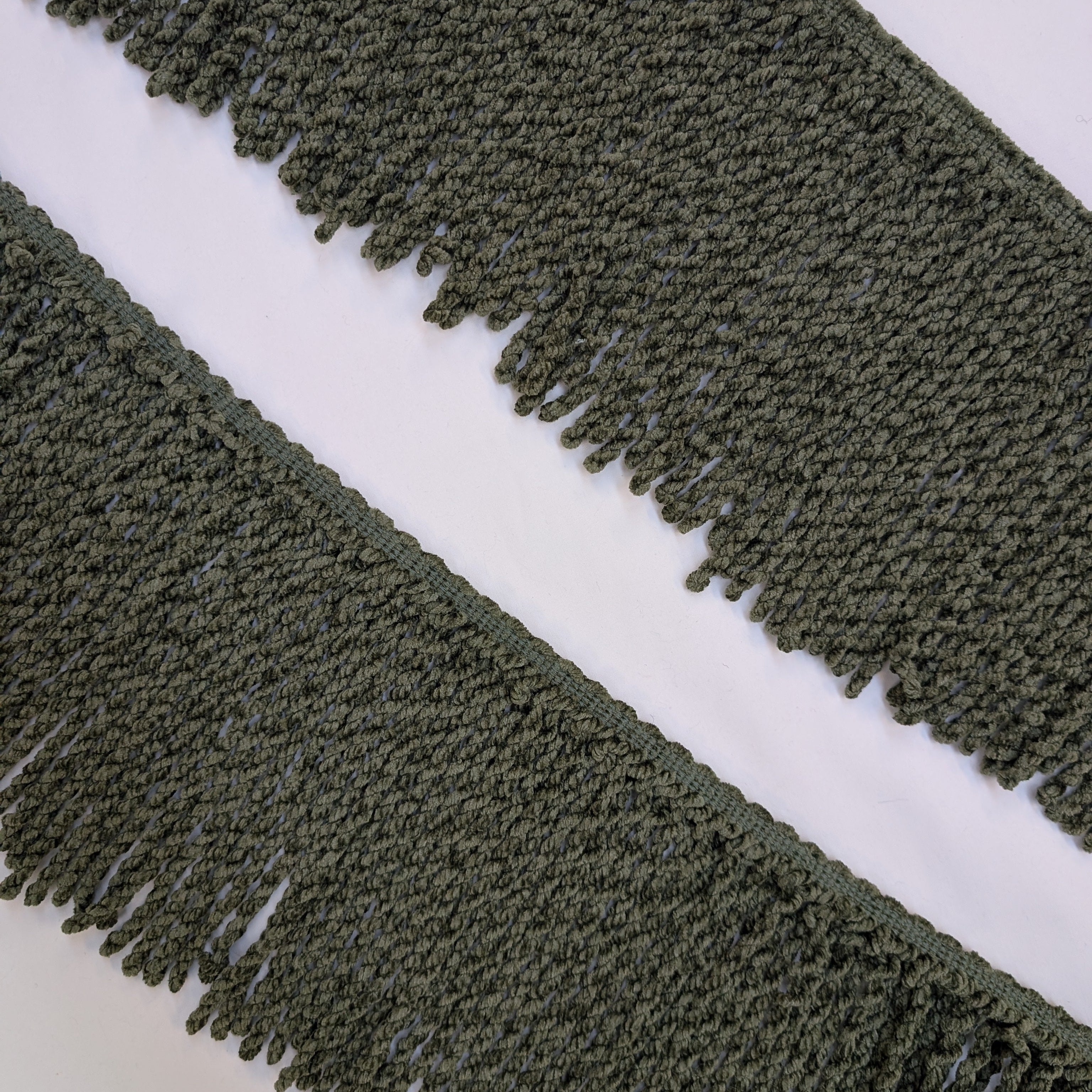 Close-up of green fringe fabric on a white background