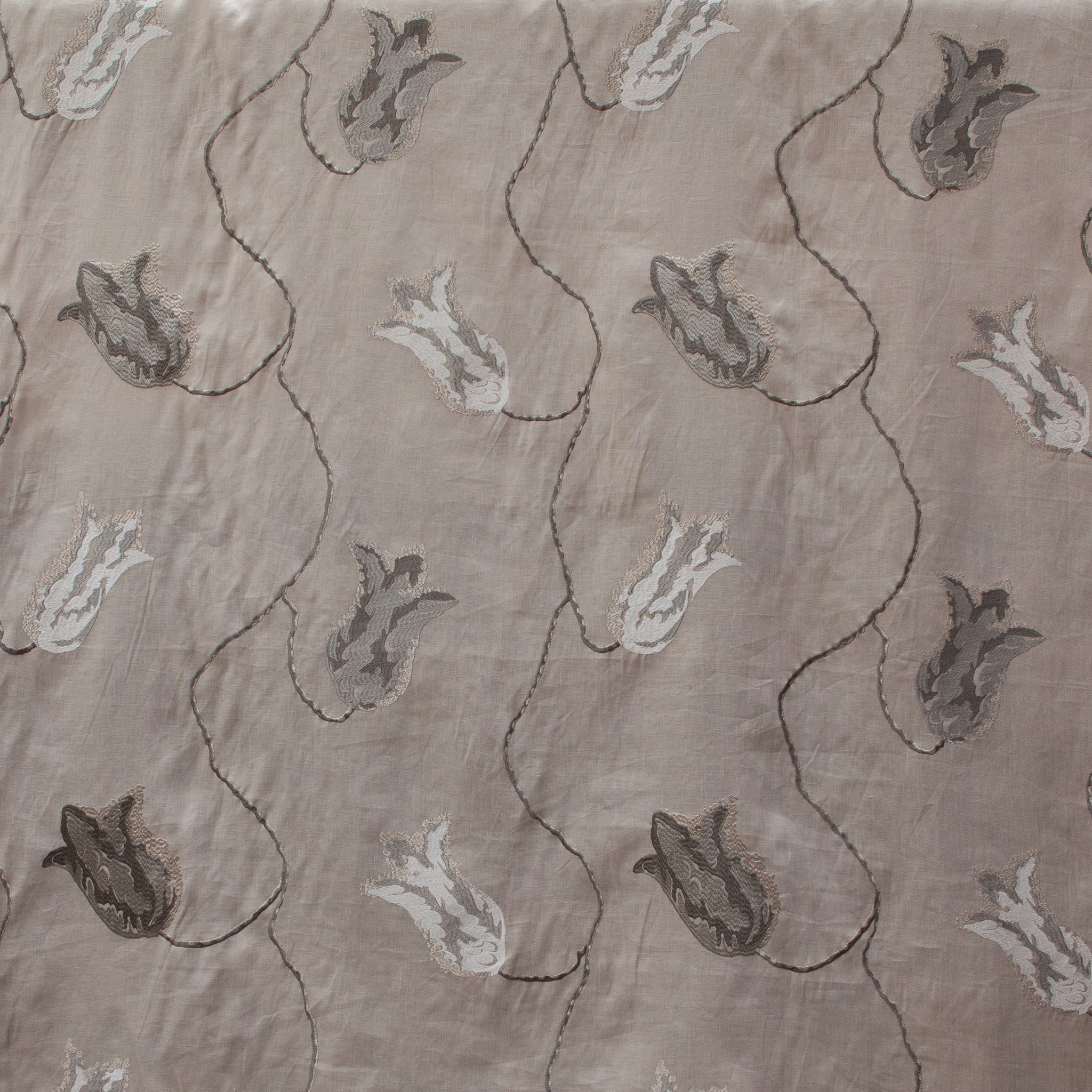 Textured fabric with embroidered floral pattern on a beige background