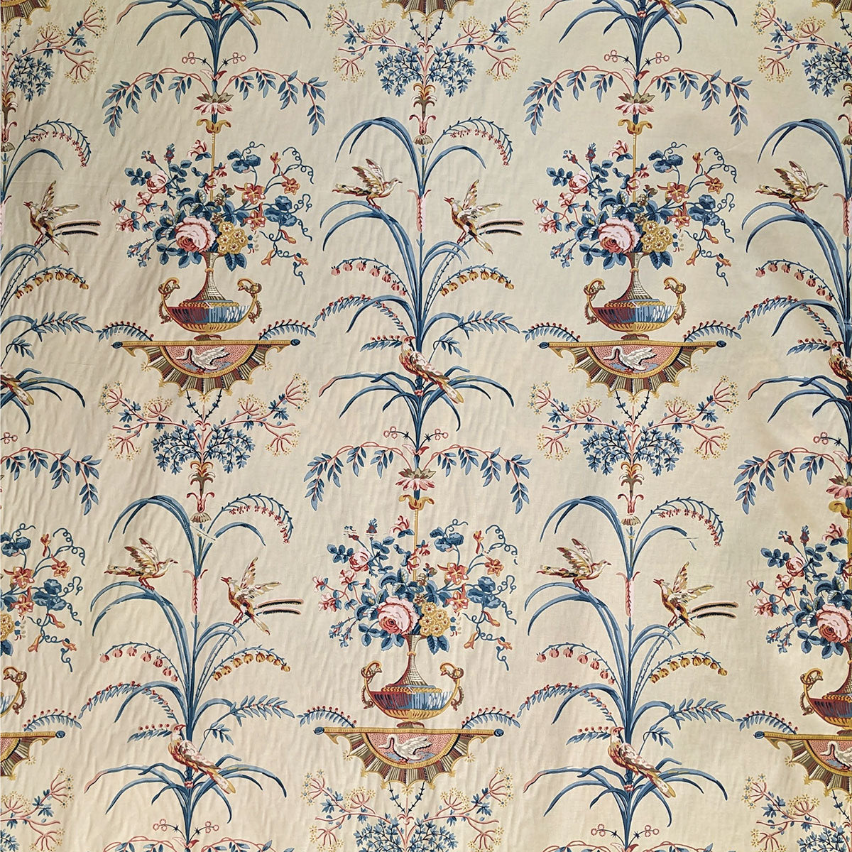 Tall grasses and vases with blue and brown flowers in on cream background 