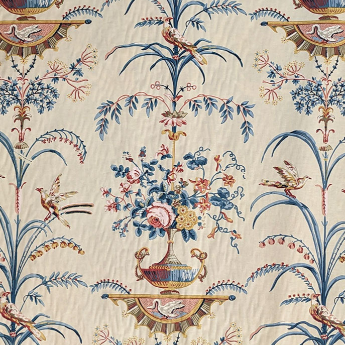 Tall grasses and vases with blue and brown flowers in on cream background 