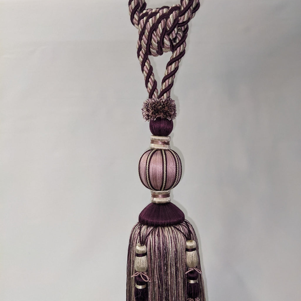 Decorative tassel with braided design on a white background