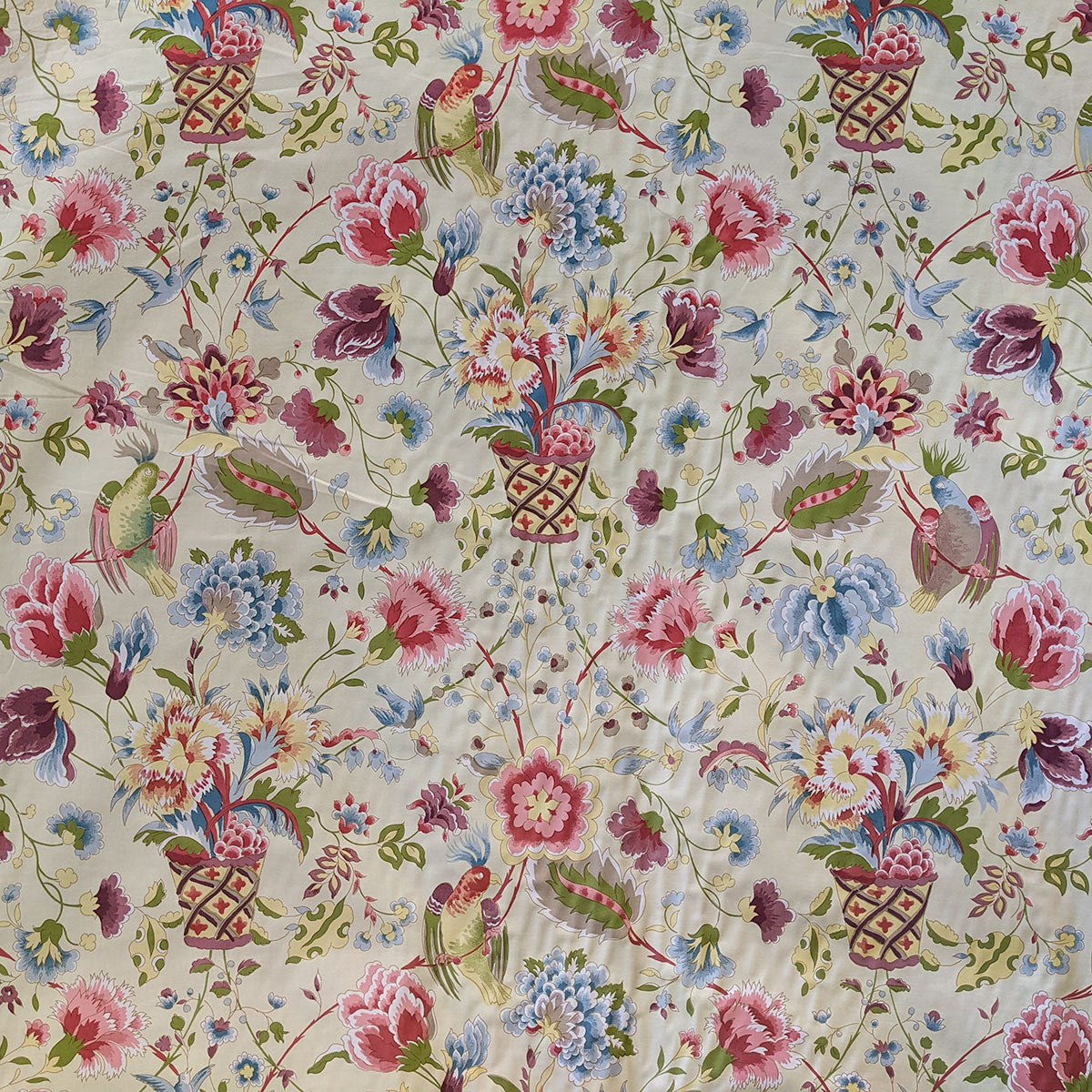 Bird and flowers in baskets with purple, blue and pink with a cream background fabric