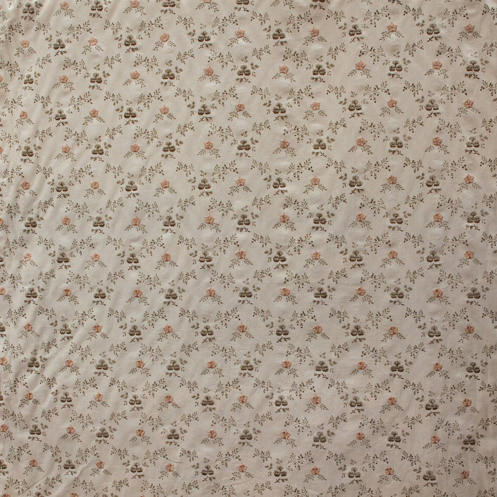 Floral patterned fabric with small flowers and leaves on a beige background