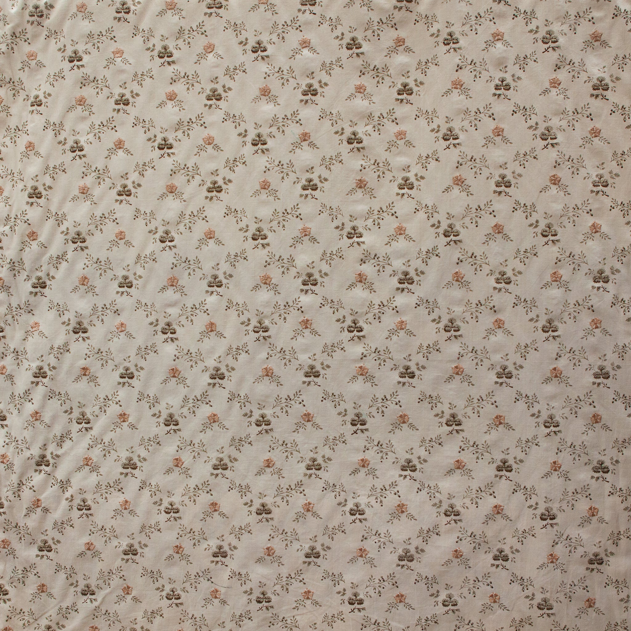 Floral patterned fabric with small flowers and leaves on a beige background