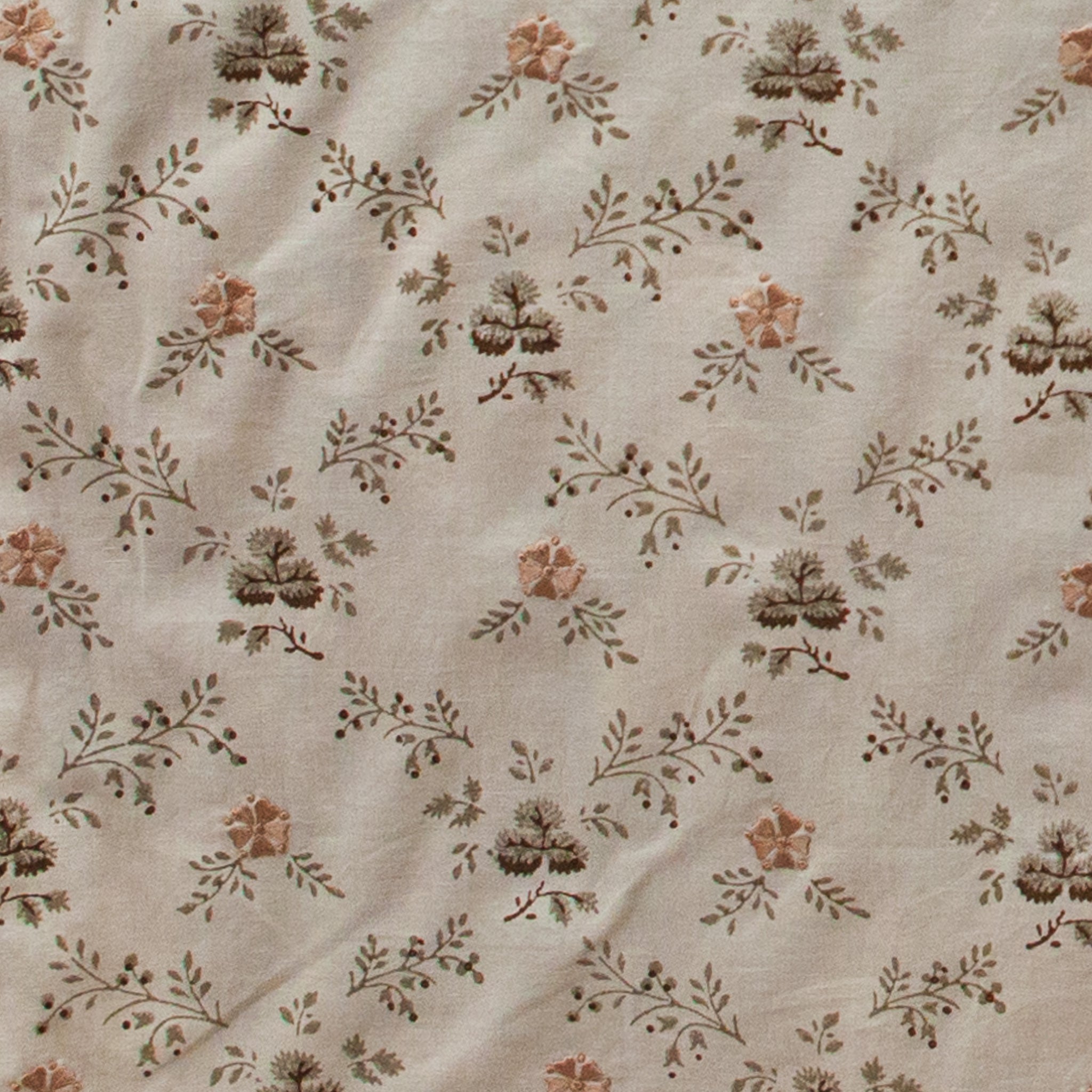 Floral patterned fabric with small flowers and leaves on a beige background