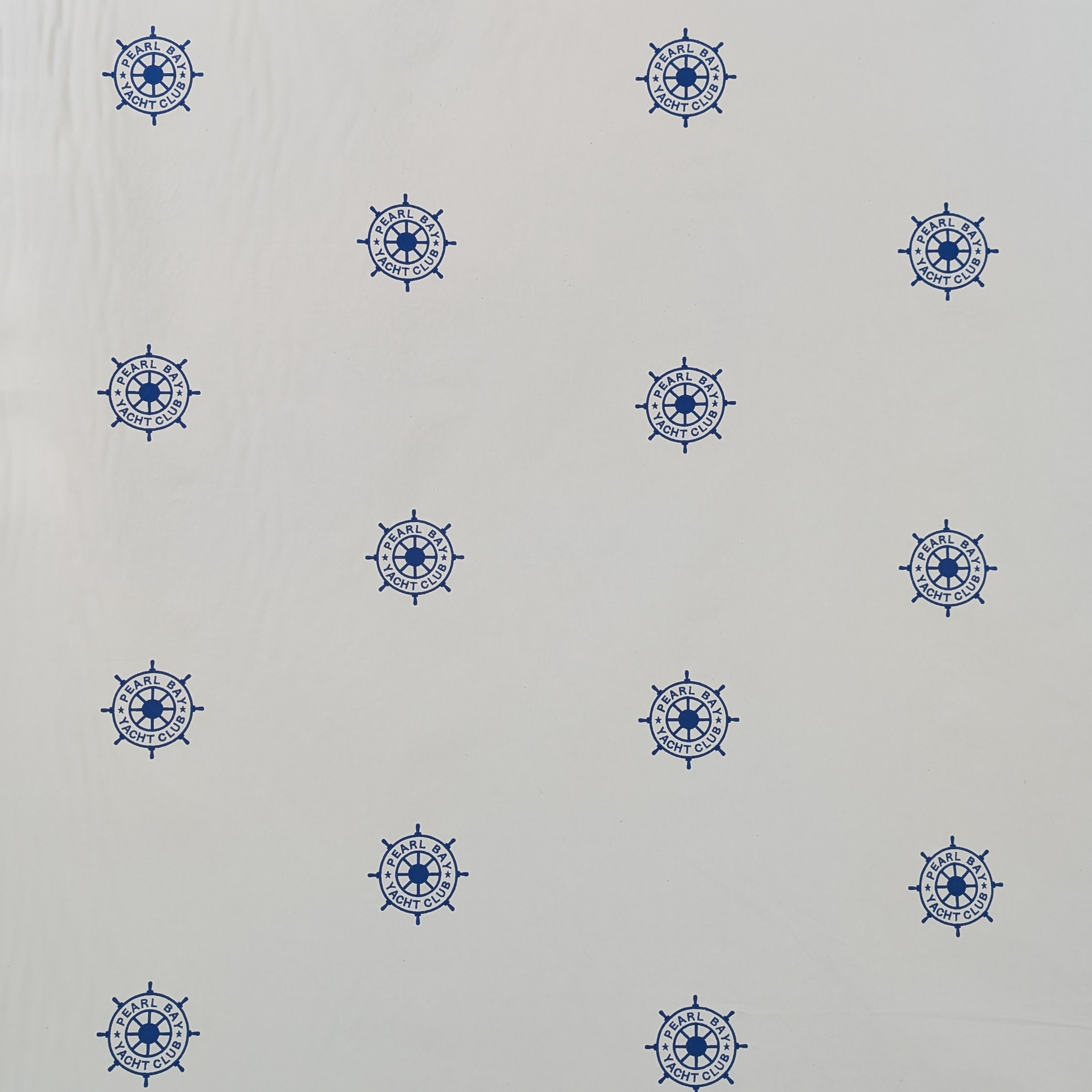 Embroidered Blue ships steering wheel logo on a white background