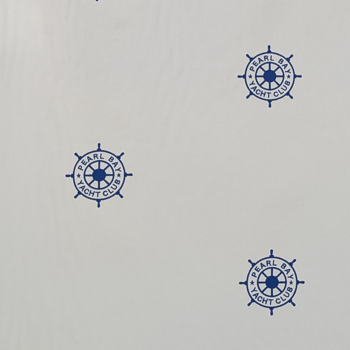 Embroidered Blue ships steering wheel logo on a white background