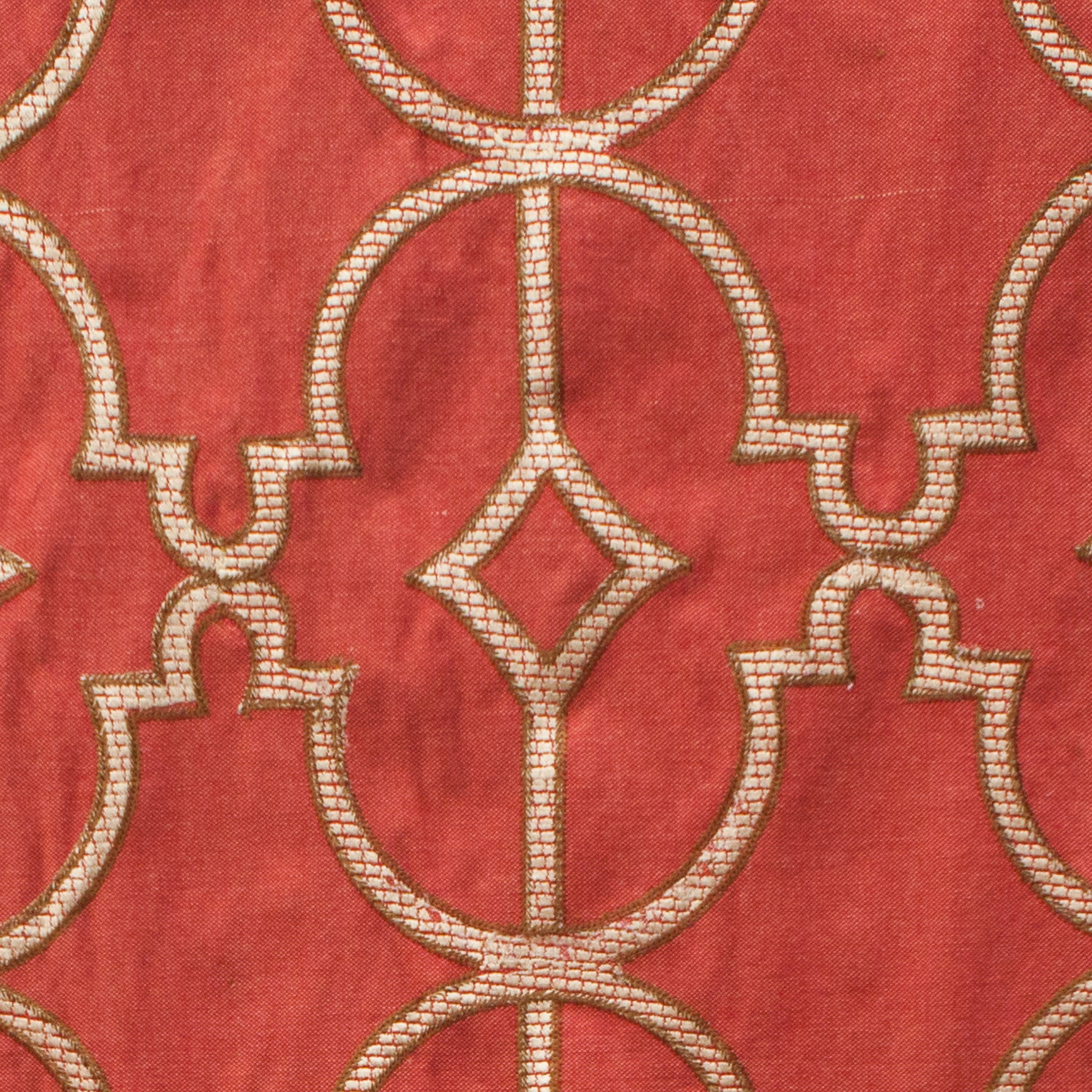 Close-up of a red fabric with gold geometric pattern
