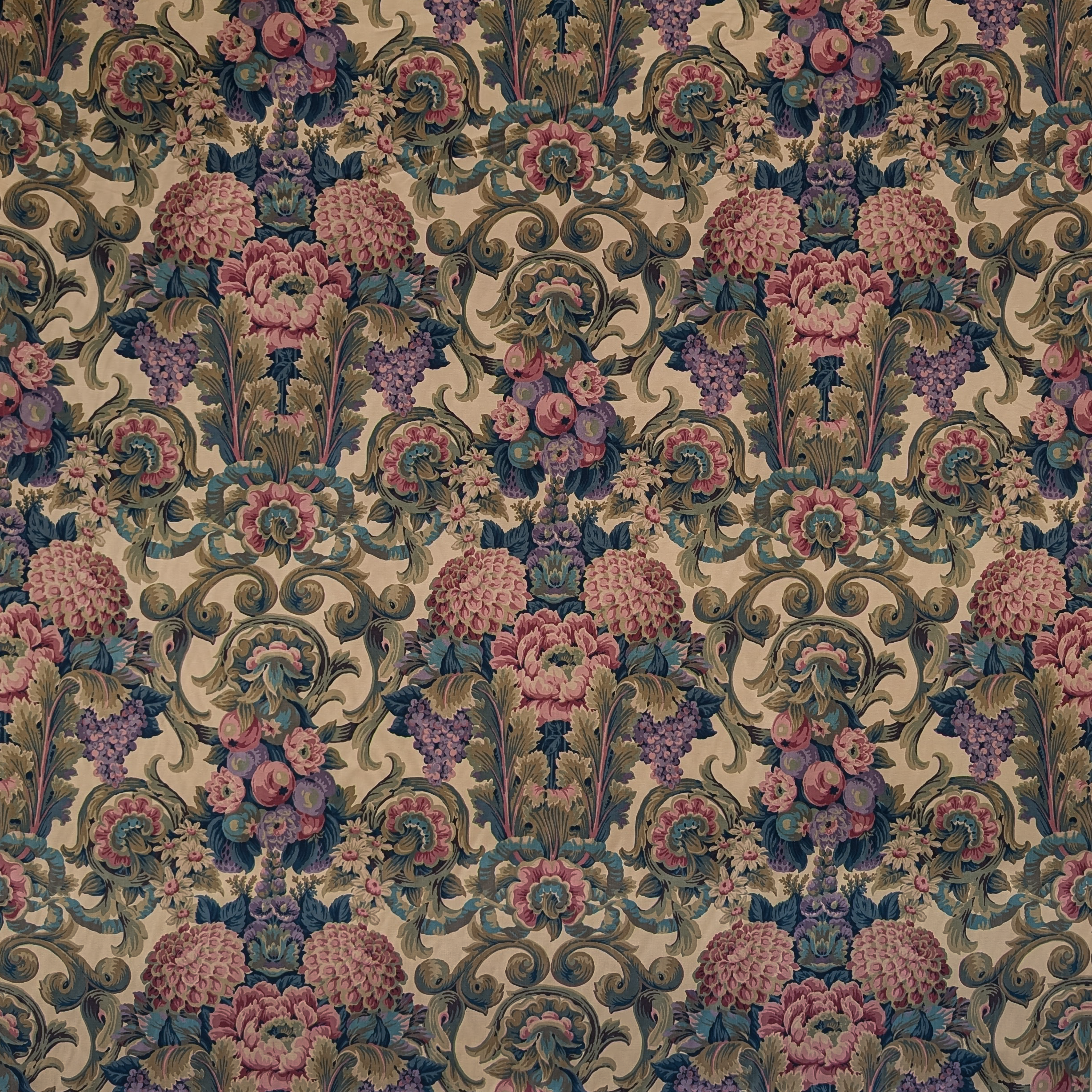 Decorative fabric pattern with flowers and swirls in pink, purple, and green on a beige background.
