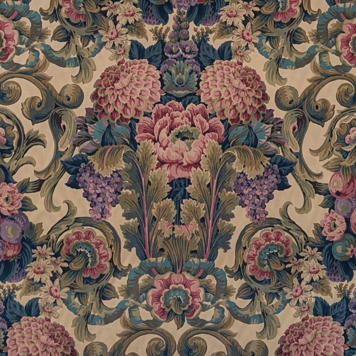 Decorative fabric pattern with flowers and swirls in pink, purple, and green on a beige background.