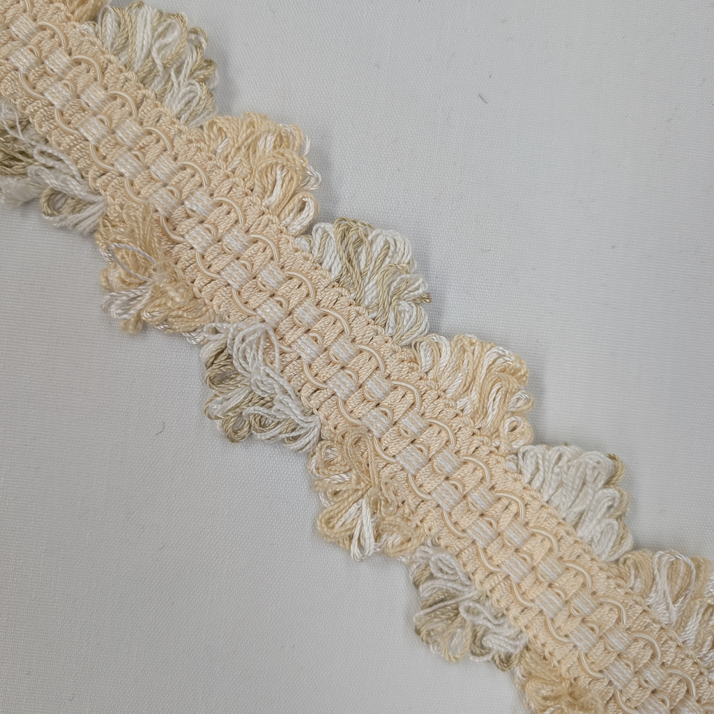Close-up of beige lace trim on a light gray background