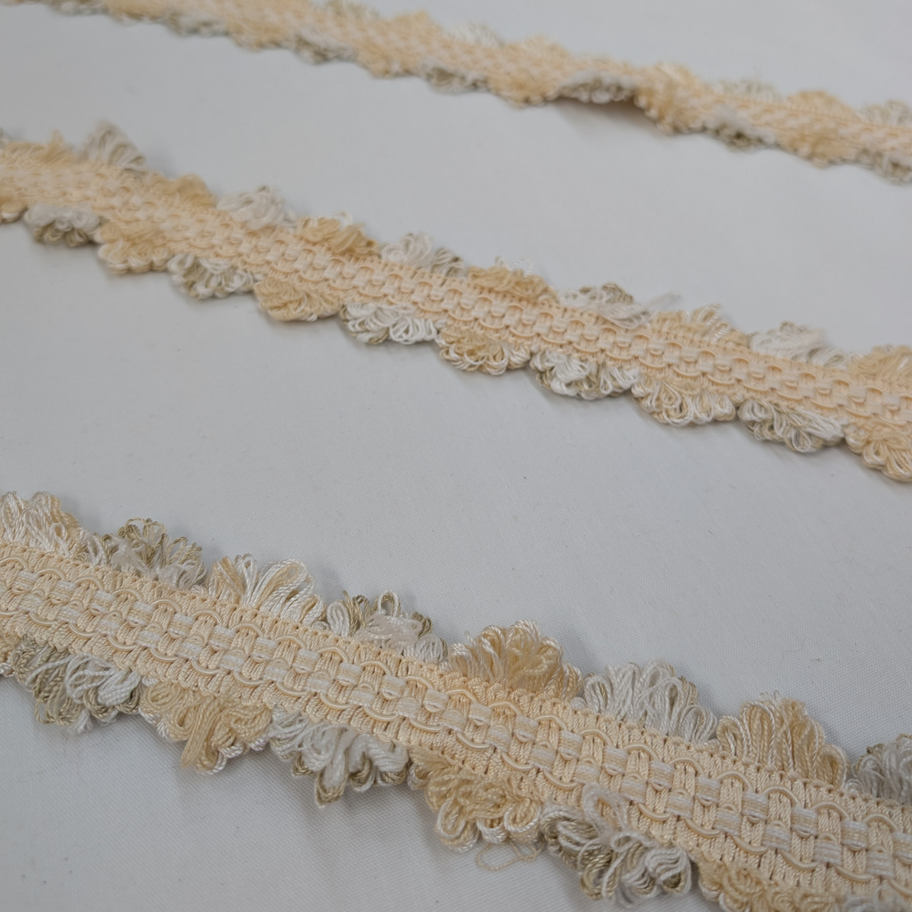 Close-up of beige lace trim on a white background