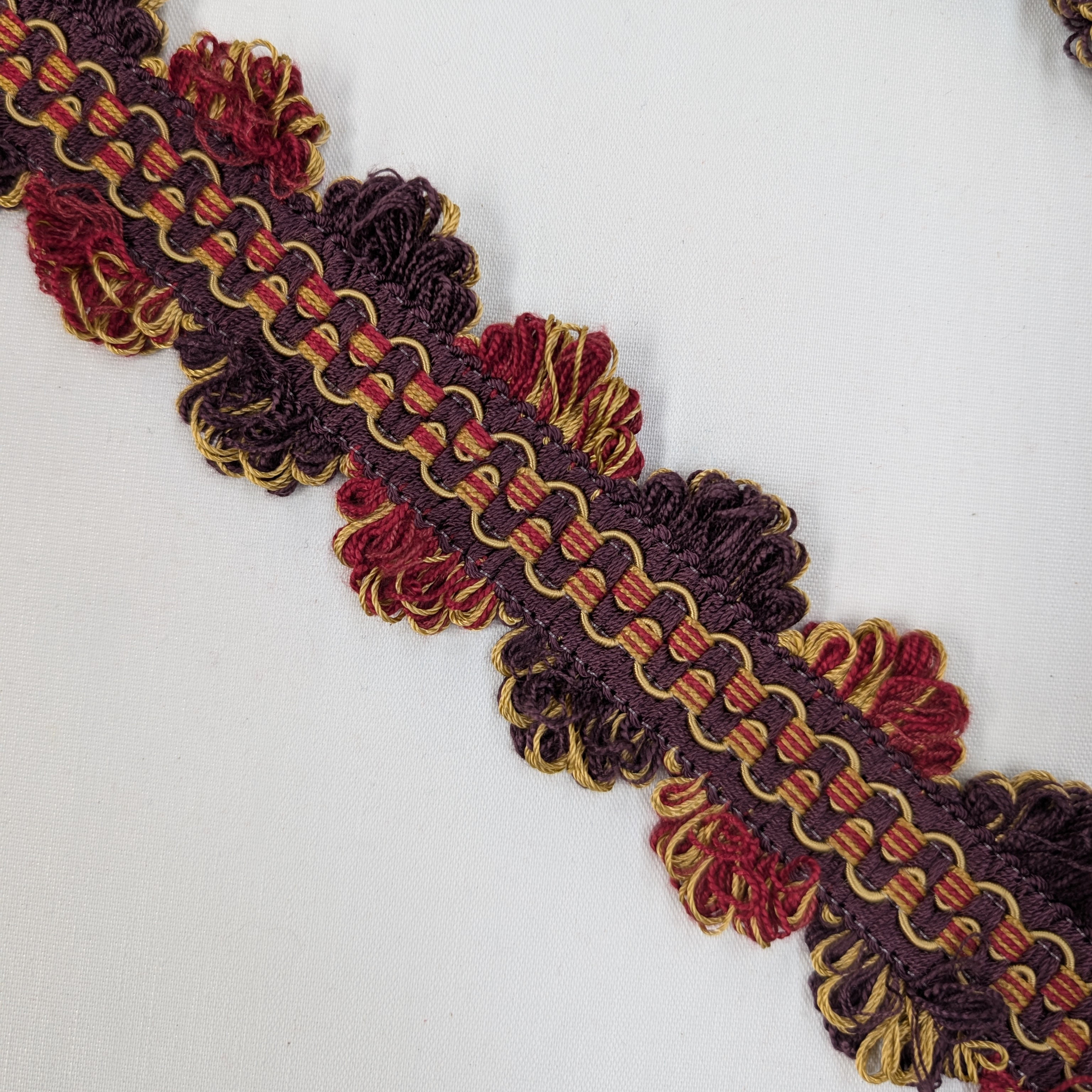 Decorative trim with Purple, red, and gold colors on a white background