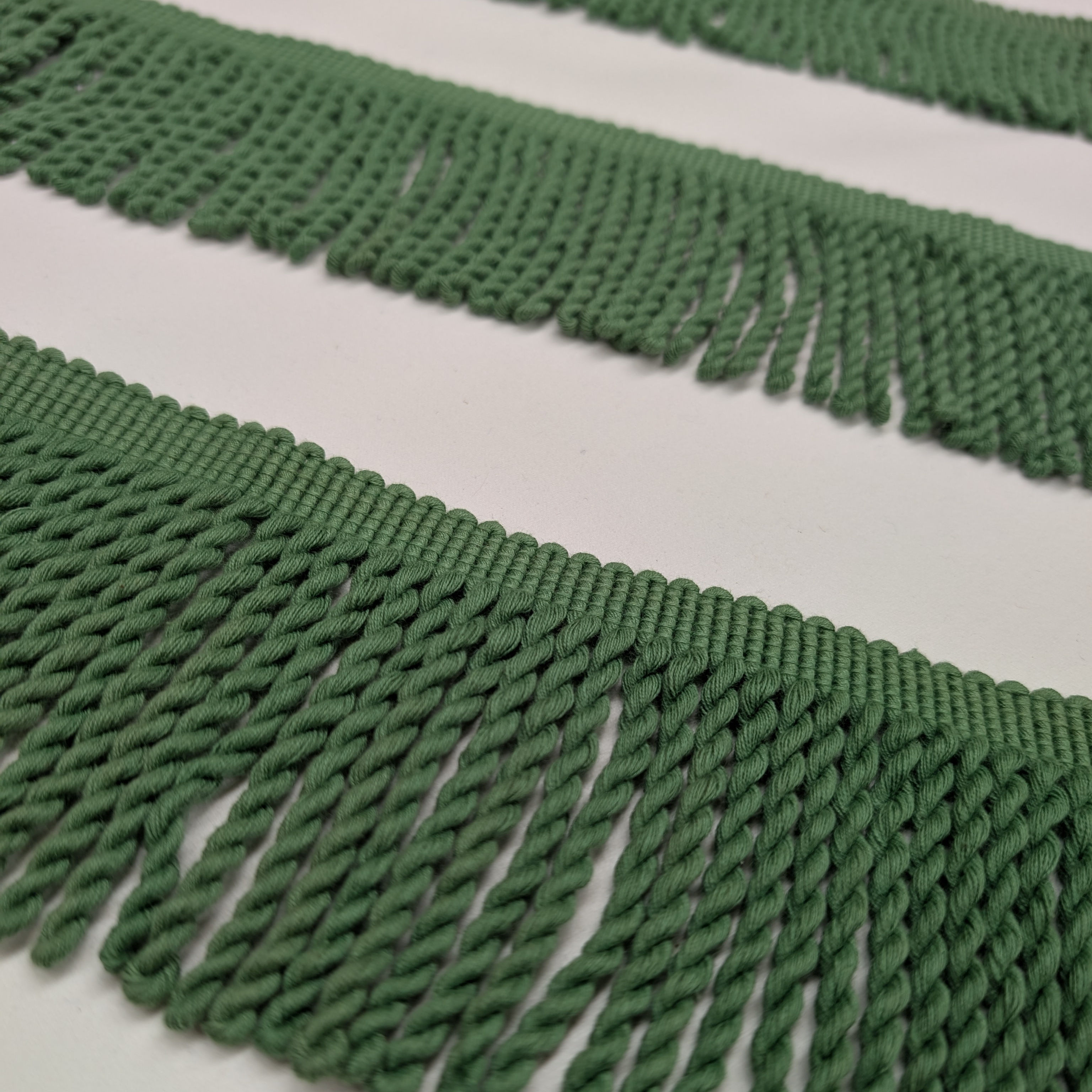 Close-up of green fringe fabric on a white background