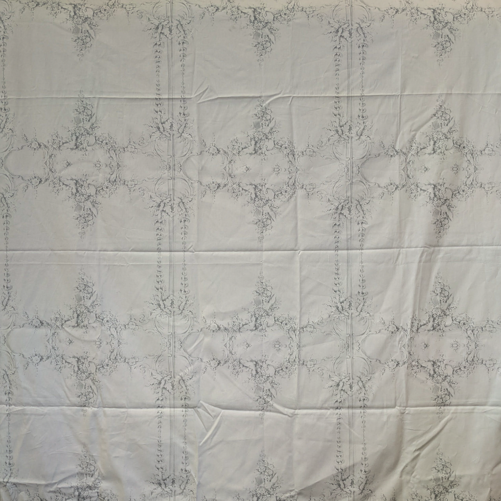 White quilt with intricate guilding pattern on a white background