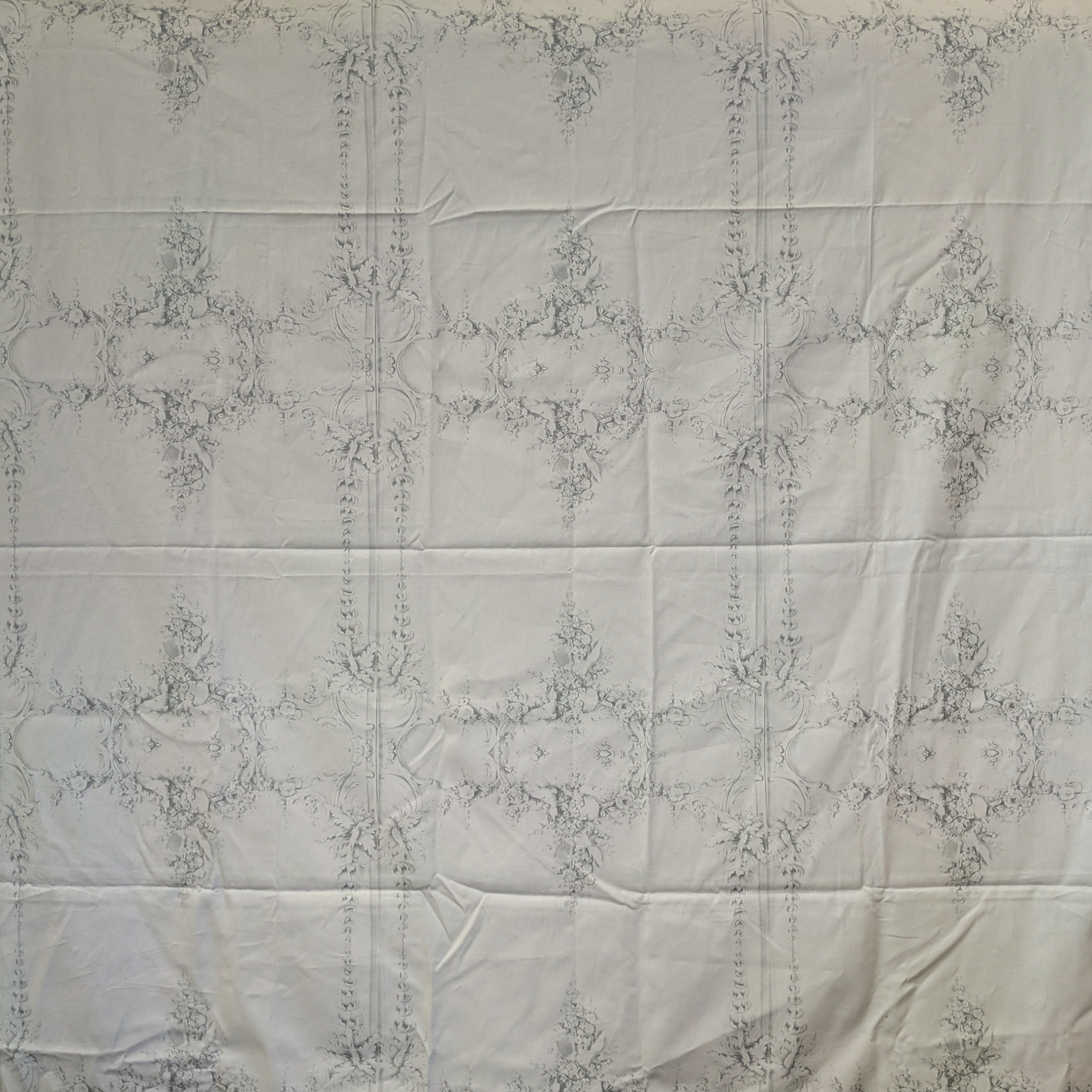 White quilt with intricate guilding pattern on a white background