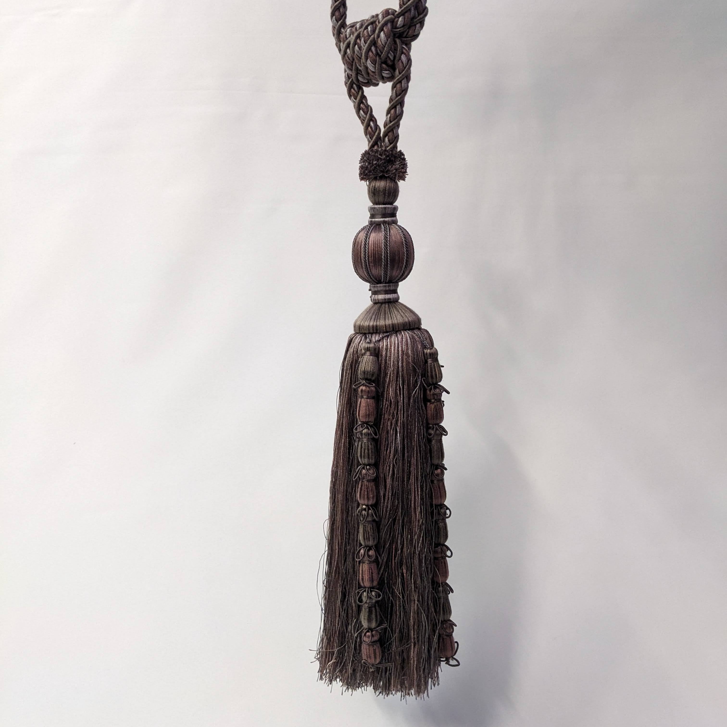 Decorative tassel with braided design on a white background