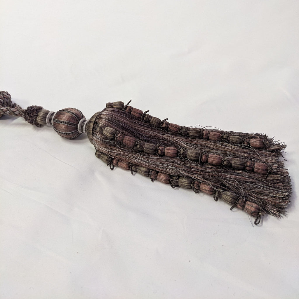 Decorative tassel with braided design on a white background