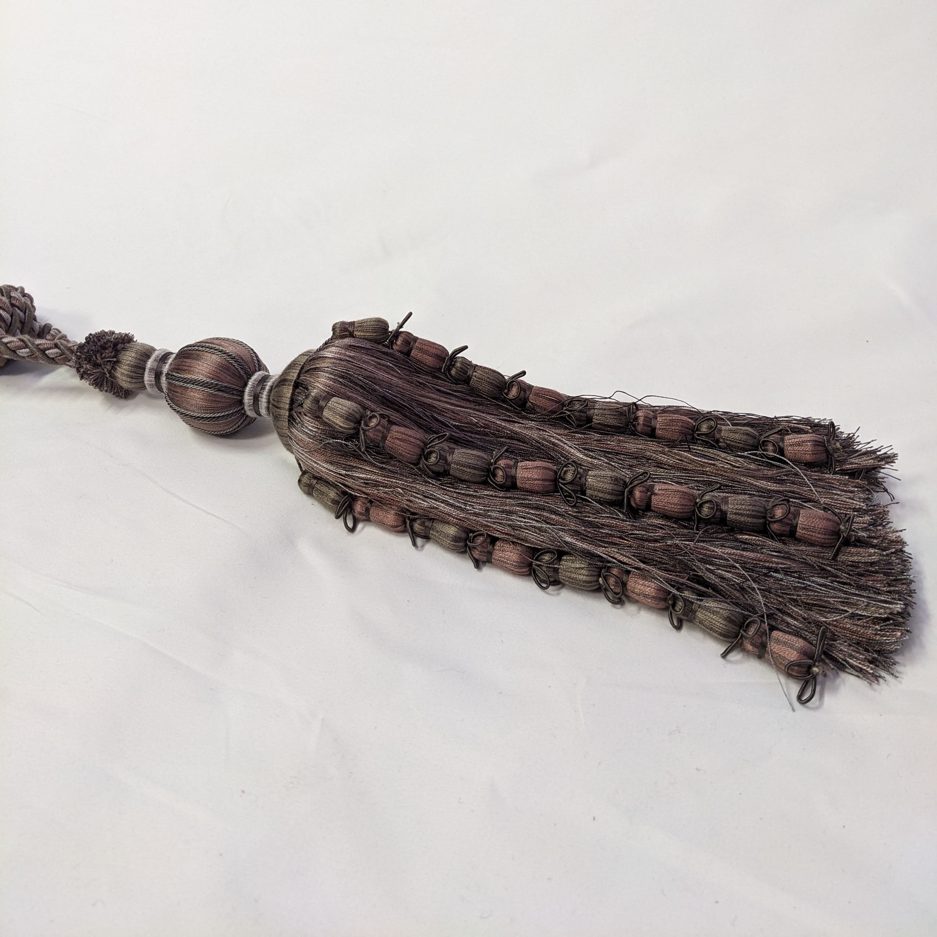 Decorative tassel with braided design on a white background