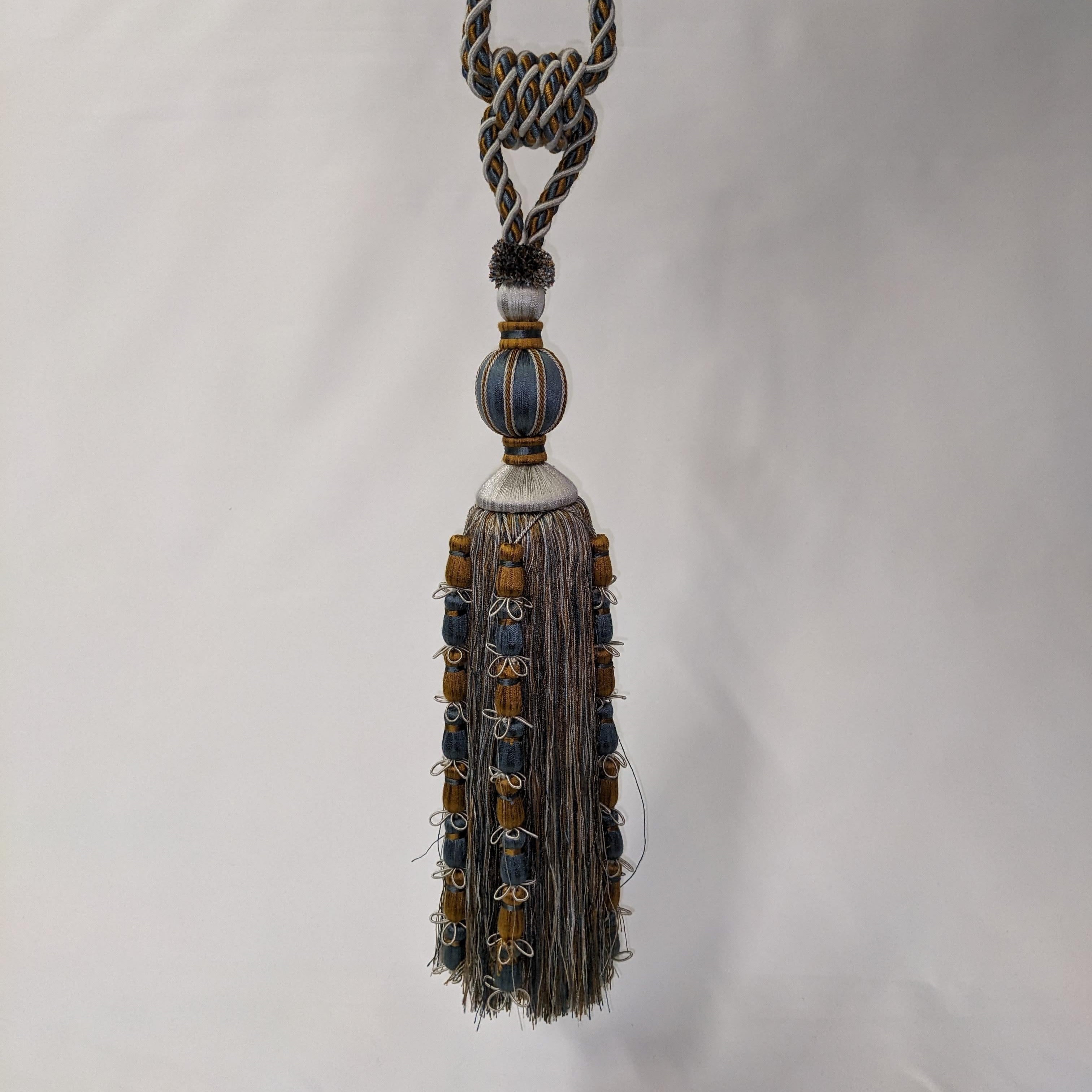 Decorative tassel with braided rope on a white background