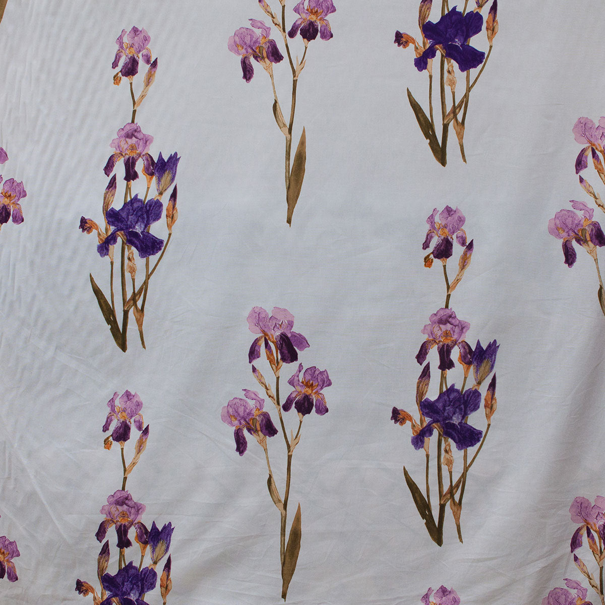 Pattern of purple and pink flowers on a textured white fabric background
