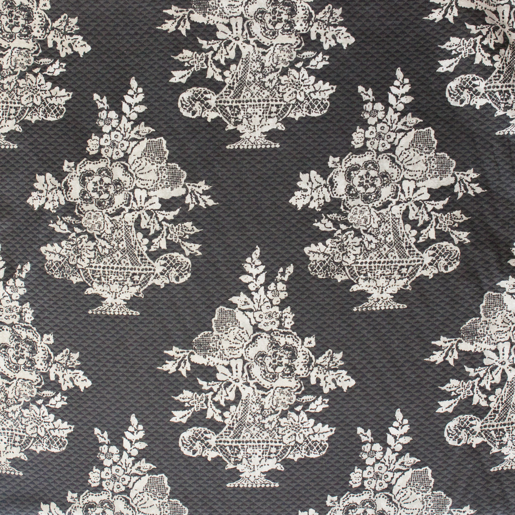 Decorative fabric pattern with floral and urn designs on a dark background