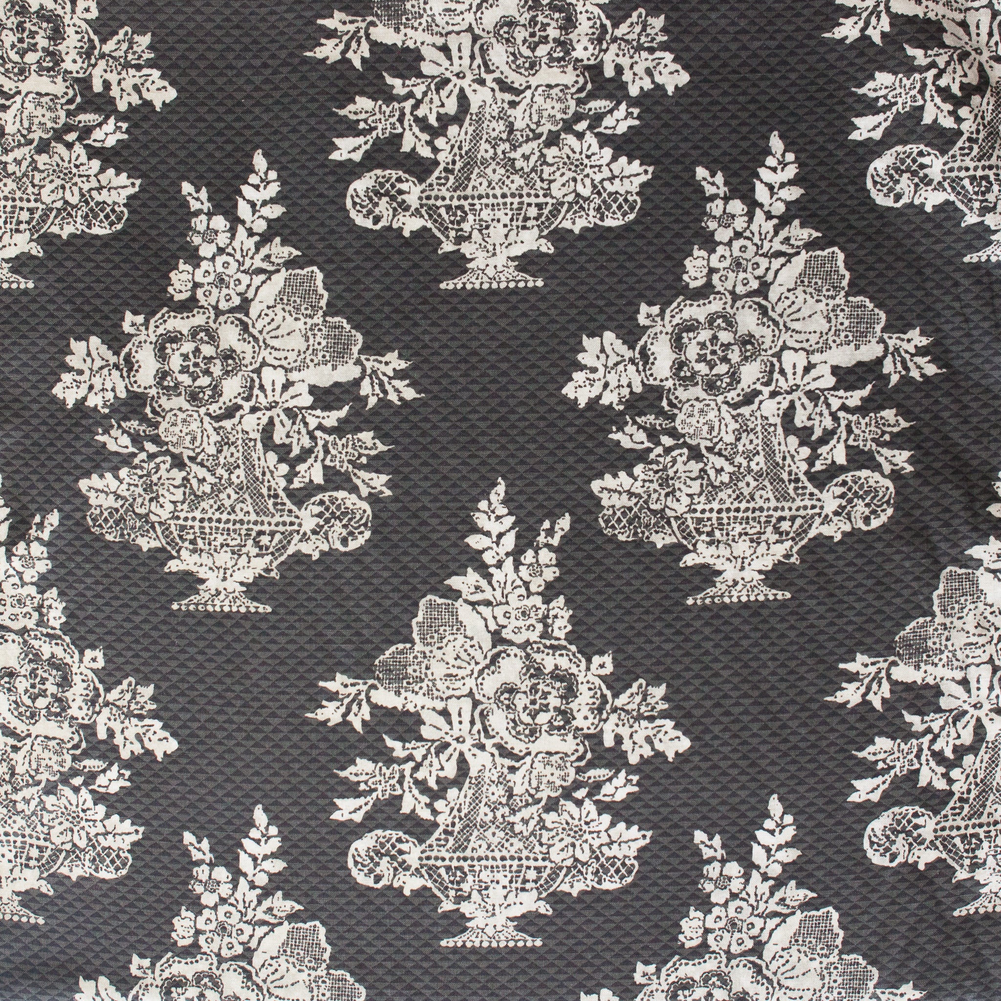 Decorative fabric pattern with floral and urn designs on a dark background