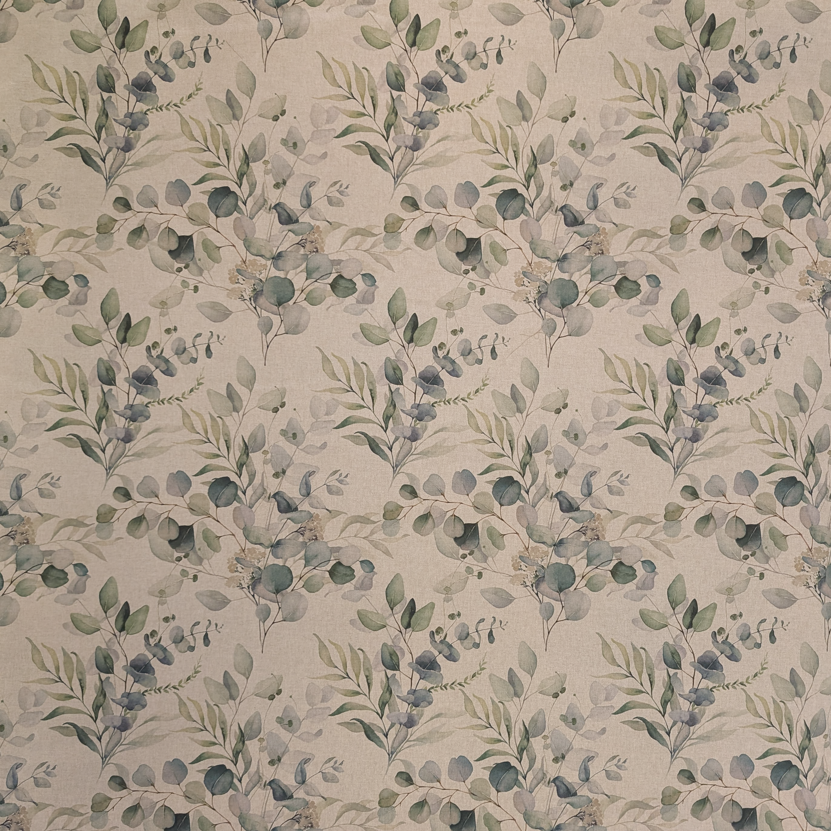 Patterned fabric with green leaves on a beige background