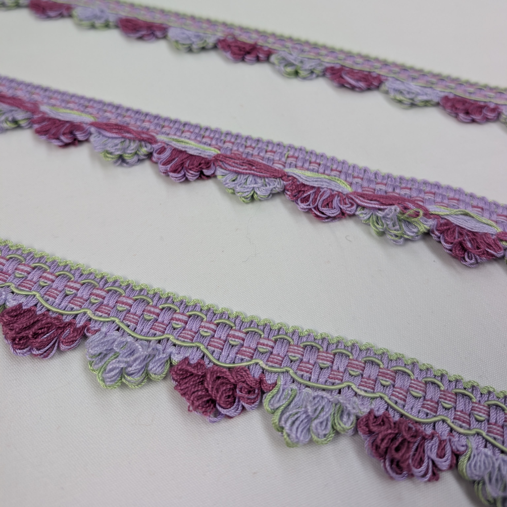 Decorative lace trim with pink and purple floral patterns on a white background