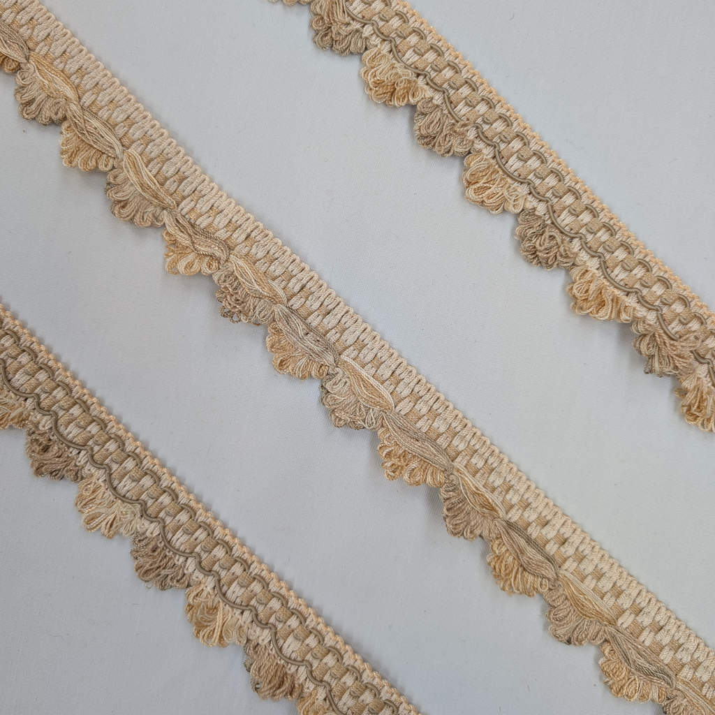 Decorative beige lace trim on a light gray background