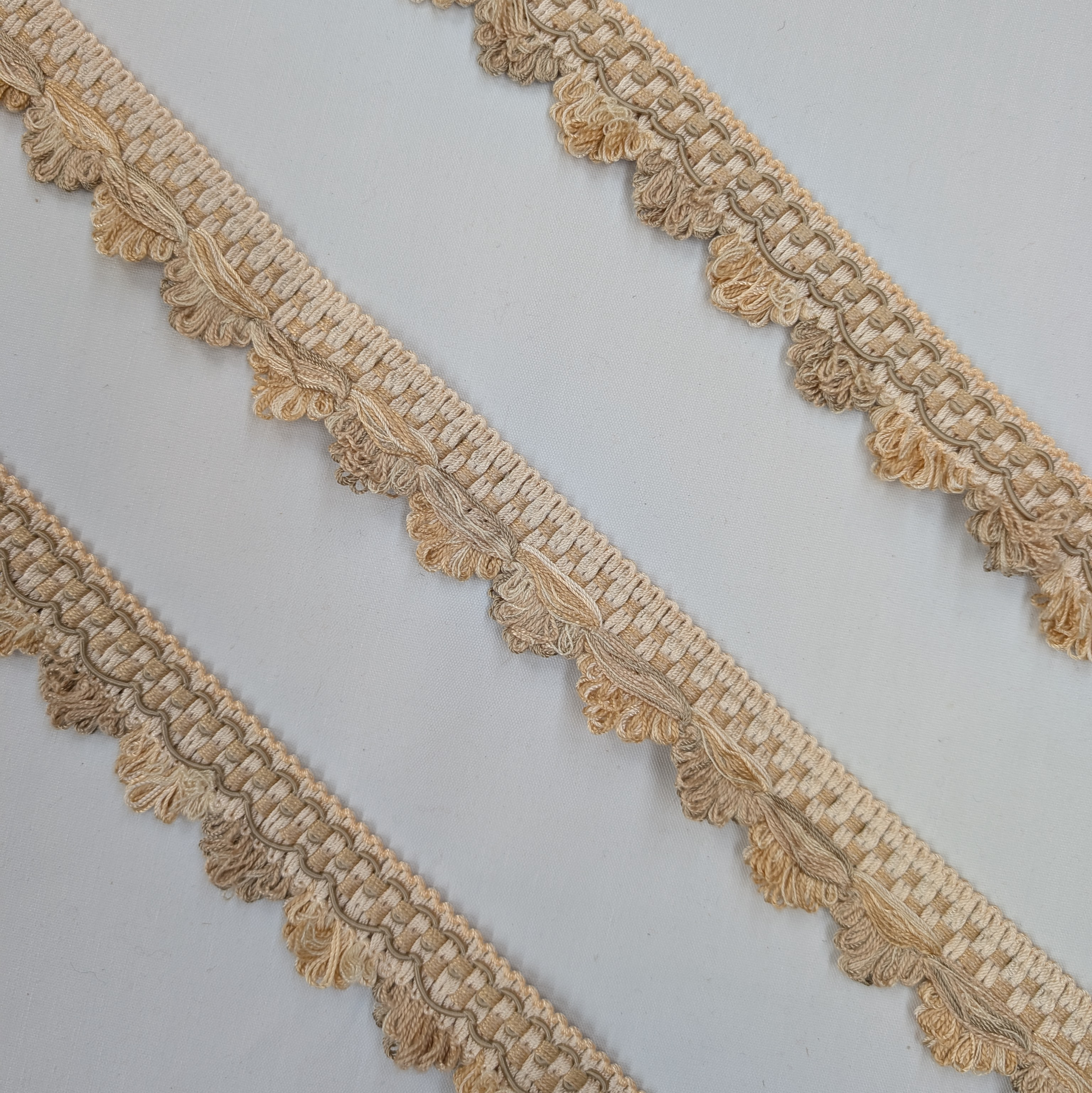 Decorative beige lace trim on a light gray background