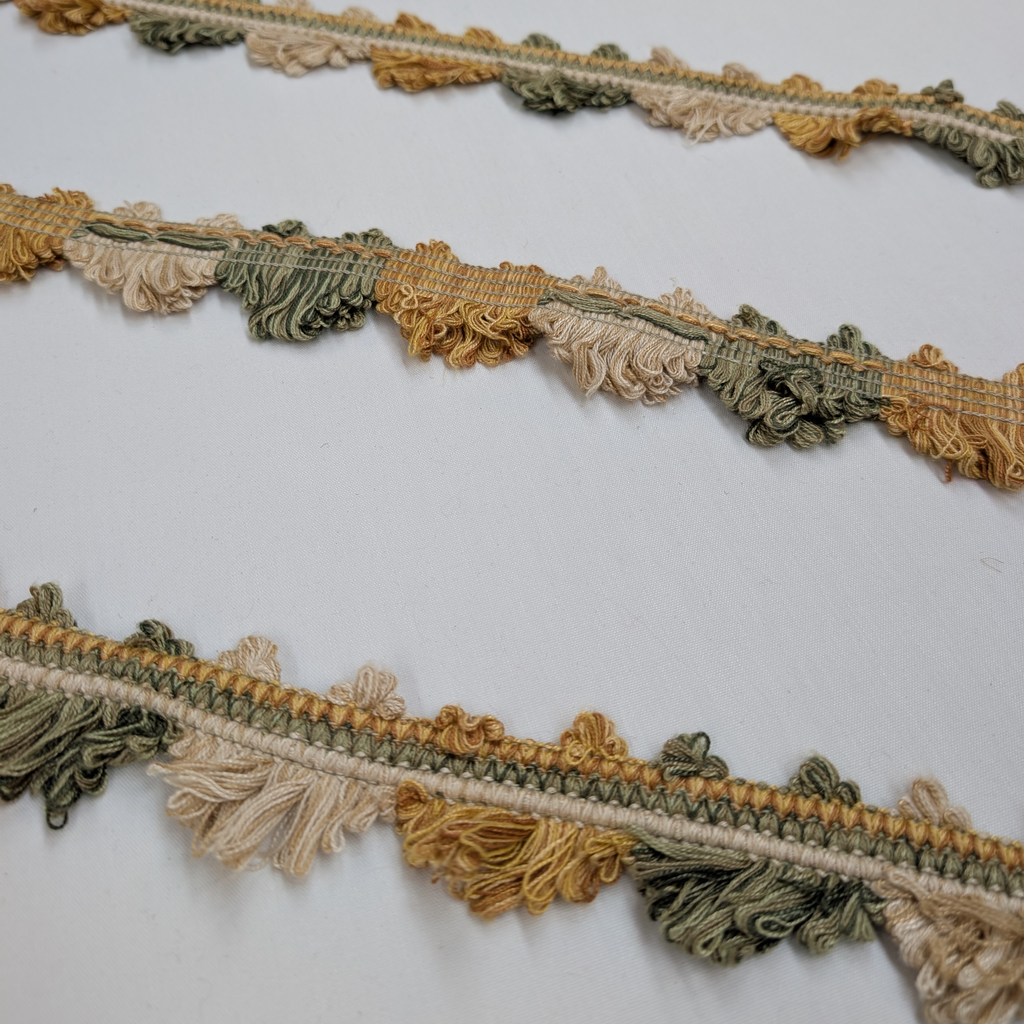 Decorative trim with tassels in earthy tones on a white background