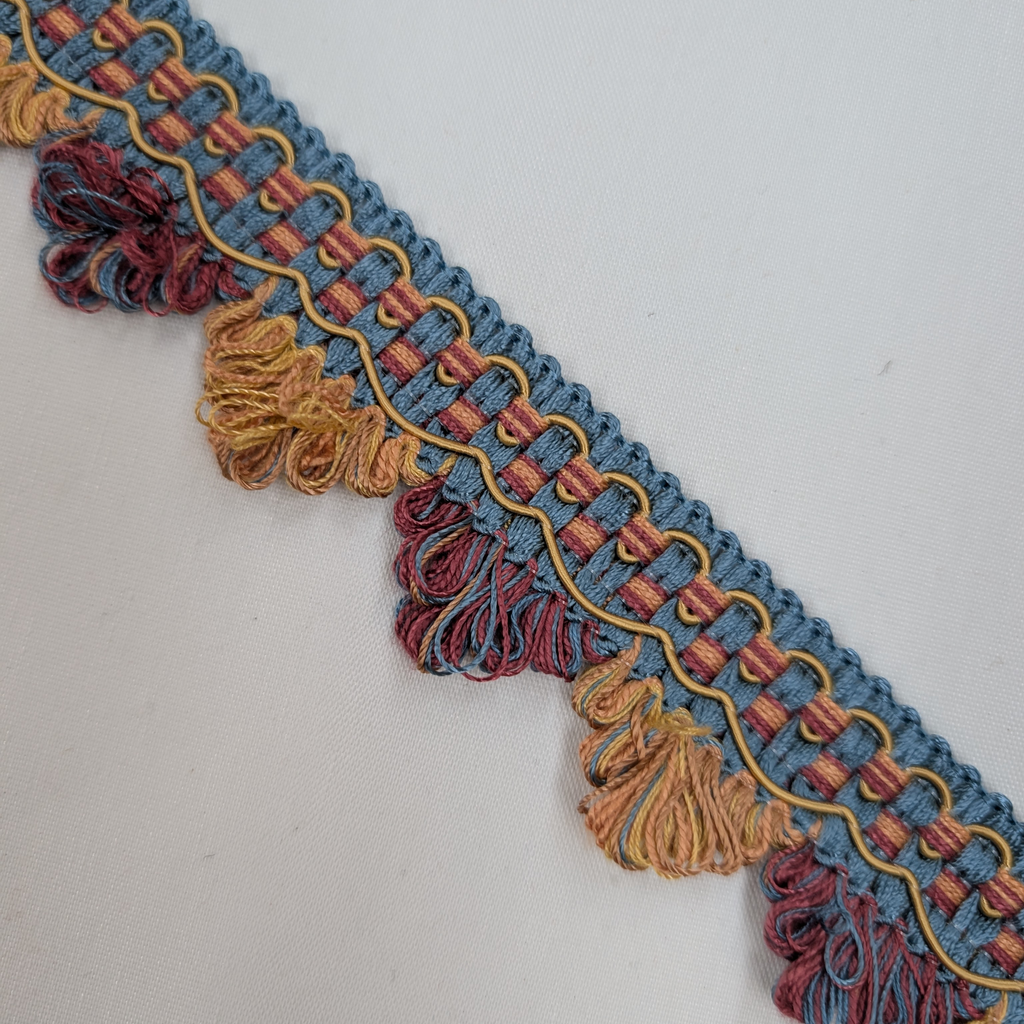 Decorative fabric trim with blue, red, and gold colors on a white background