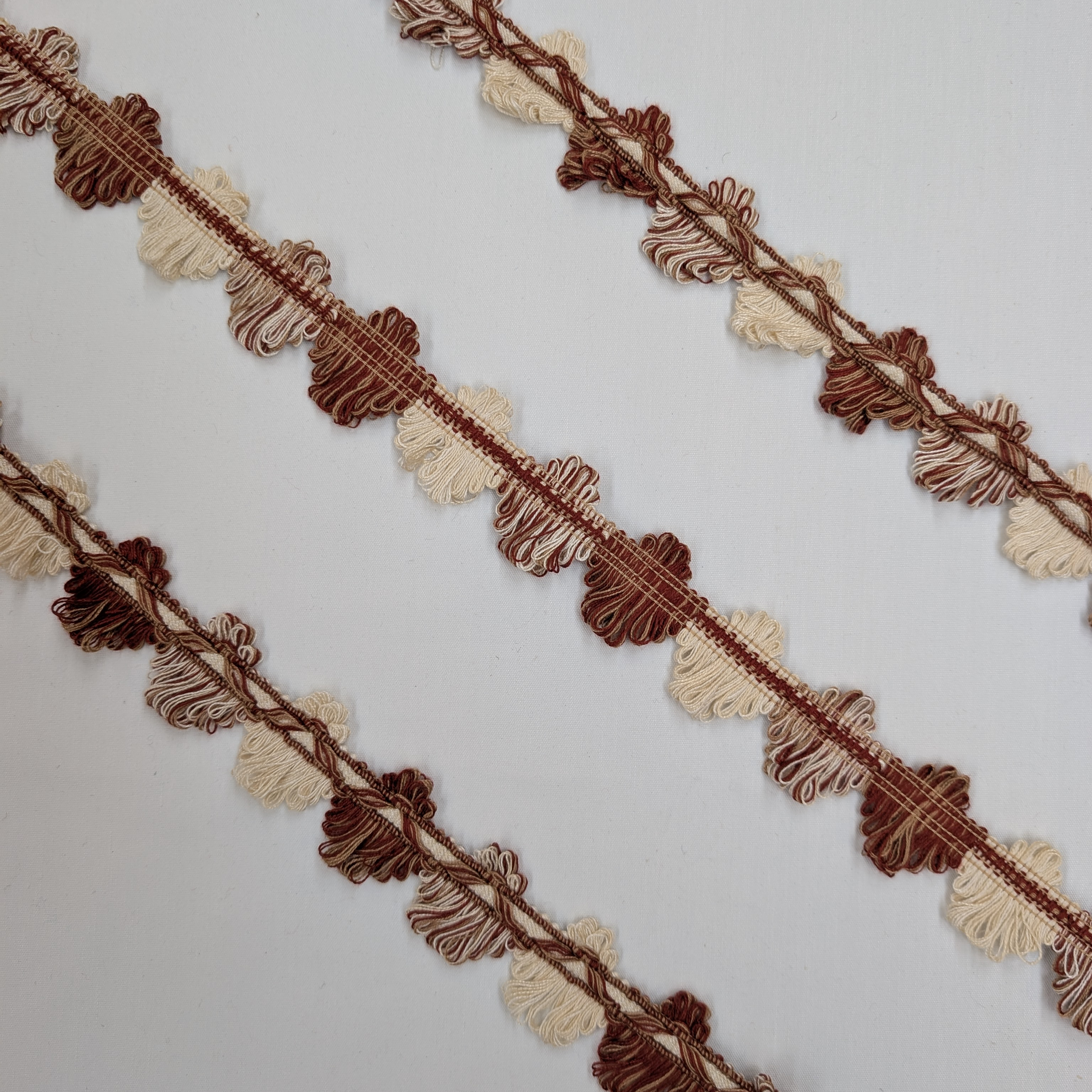 Decorative trim with red and beige leaves on a white background