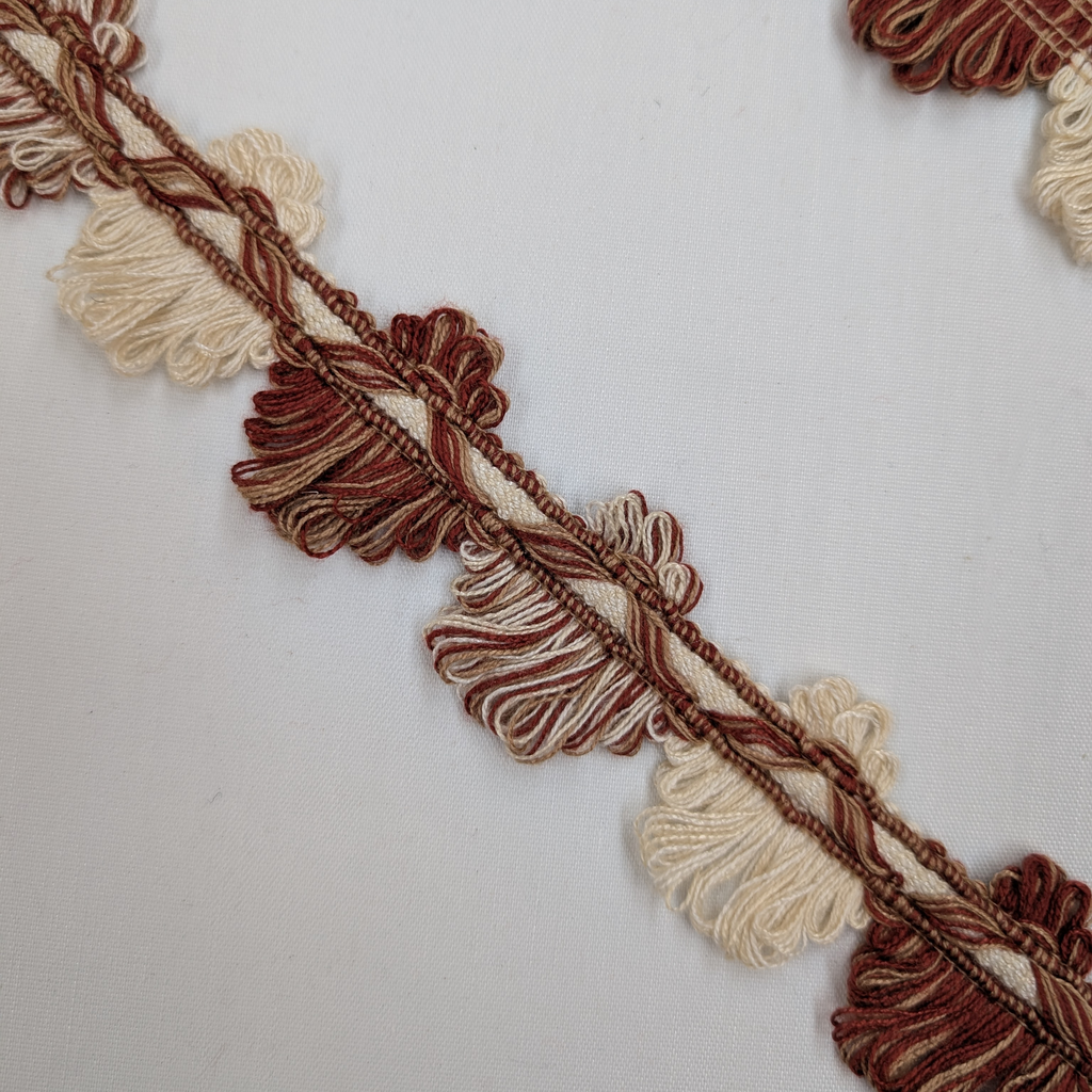 Decorative trim with brown and beige tassels on a white background