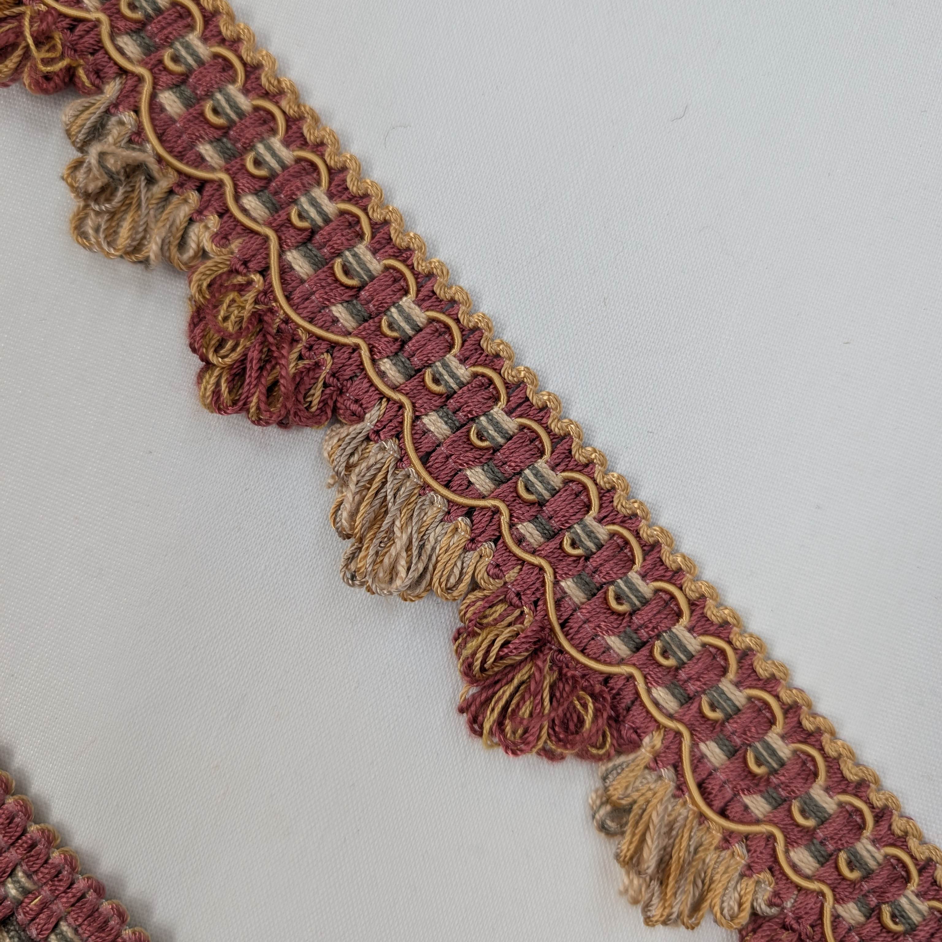 Decorative trim with red and gold colors on a white background