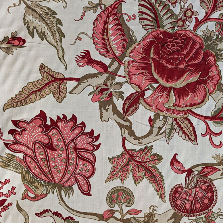 Floral and paisley patterned fabric with red and brown colors on a white background