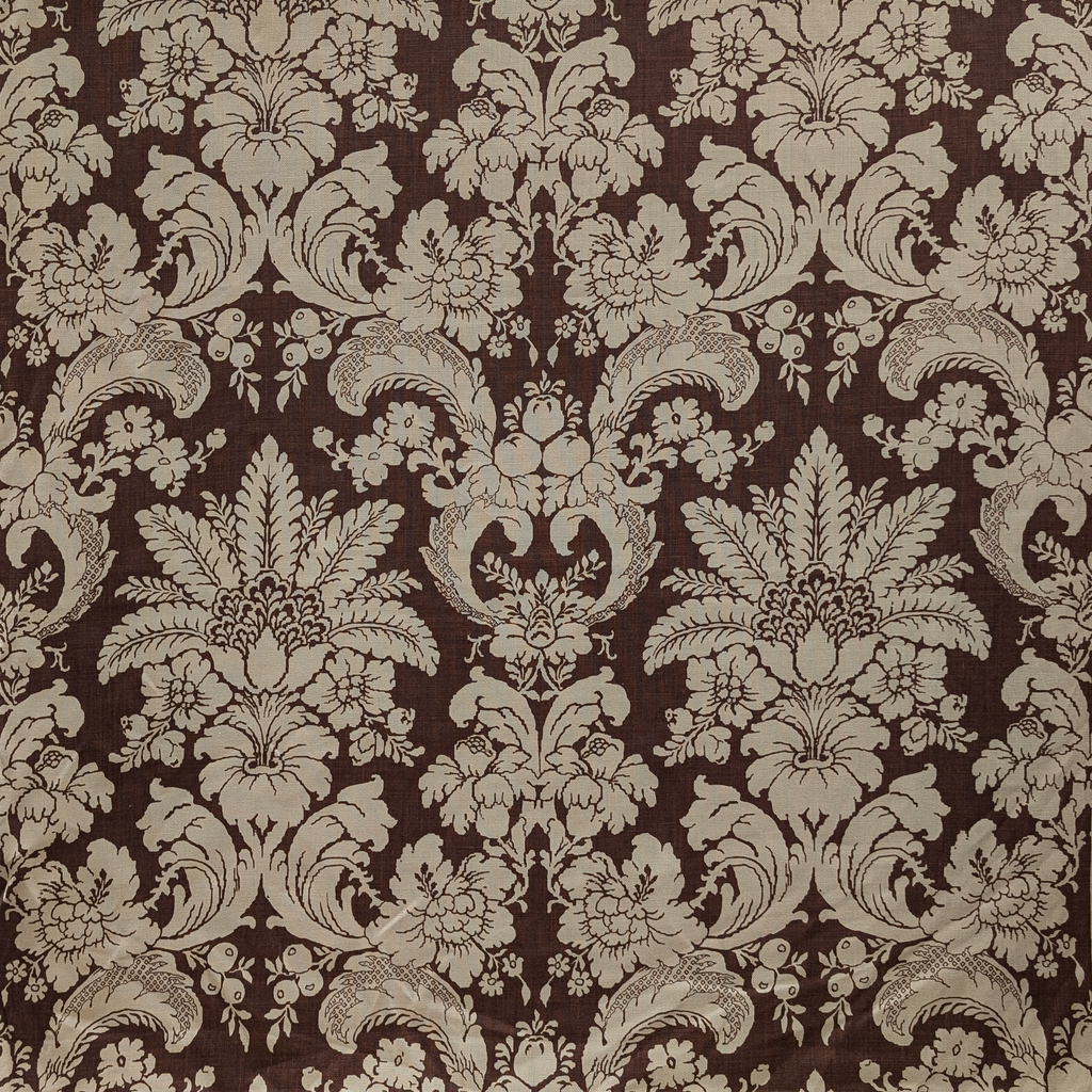 Decorative floral and leaf damask pattern on a brown background