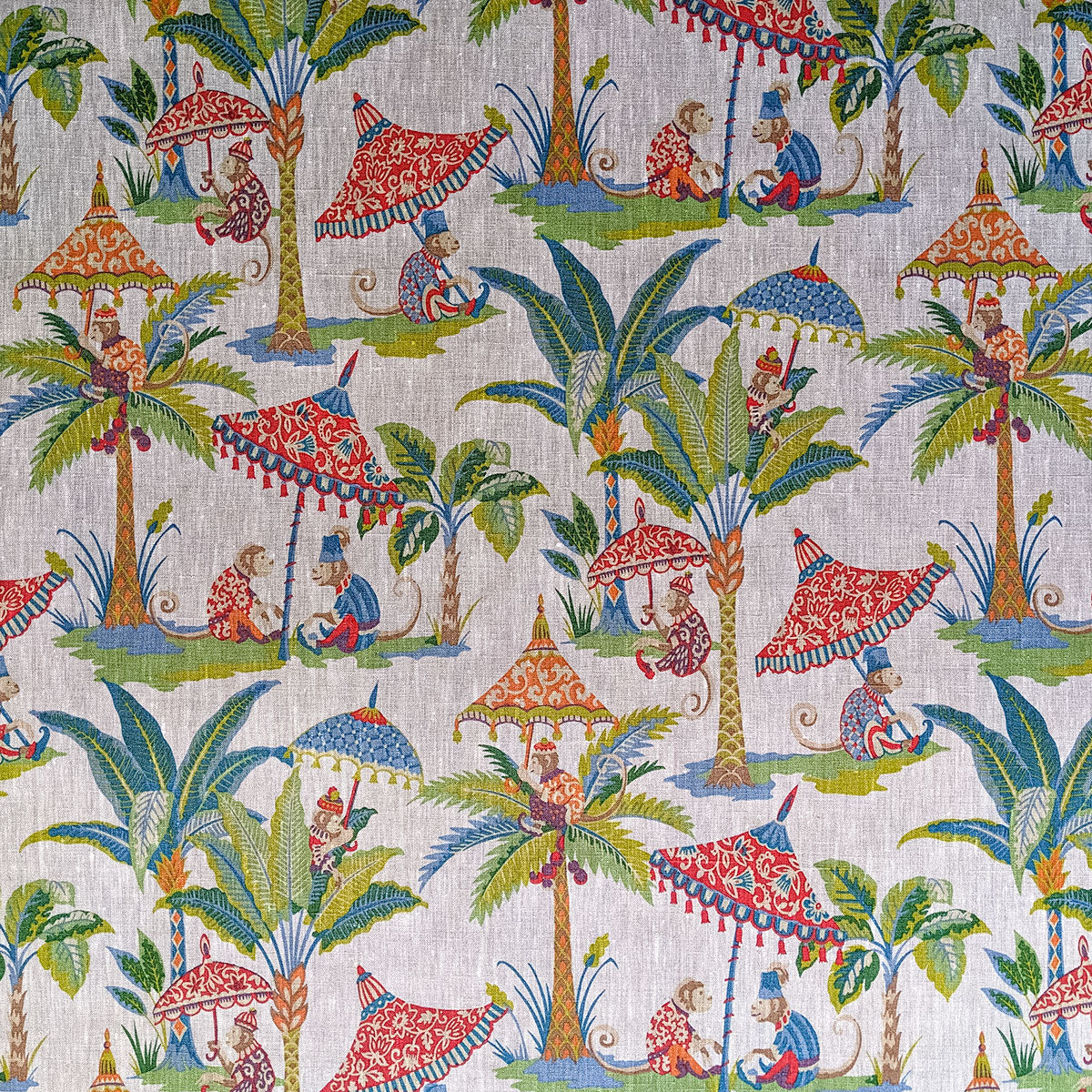 Colorful fabric pattern with palm trees, monkeys, and umbrellas on a beige background
